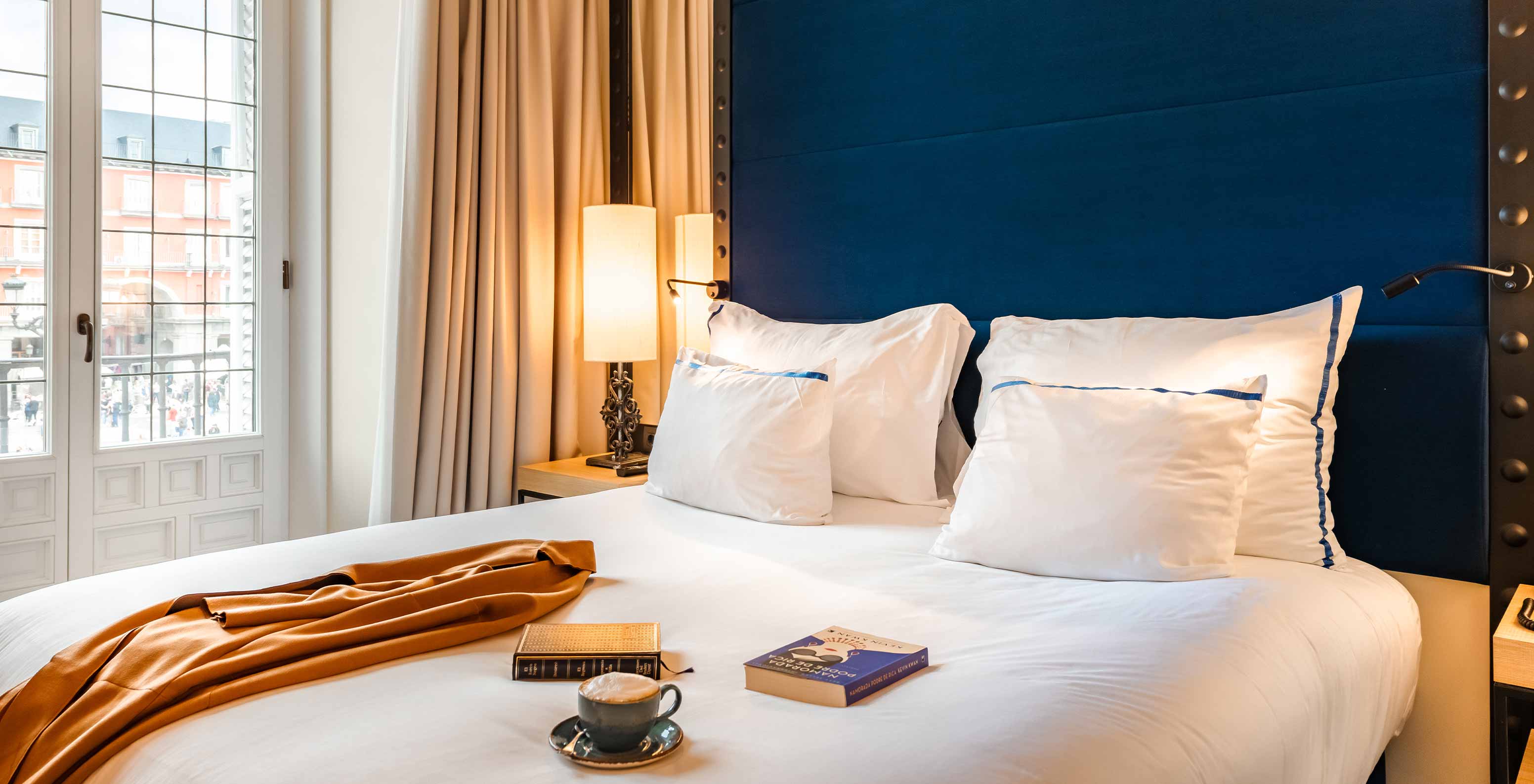 The Superior Plaza Mayor at Pestana Plaza Mayor Madrid has double bed, blue headboard, mirror, large window
