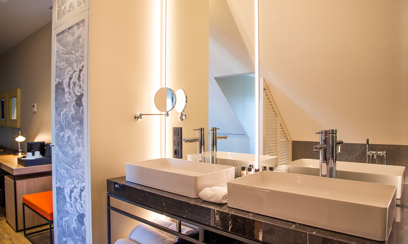 The Plaza Mayor Suite at Pestana Plaza Mayor Madrid has a bathroom with two sinks, large mirror and magnifying mirror