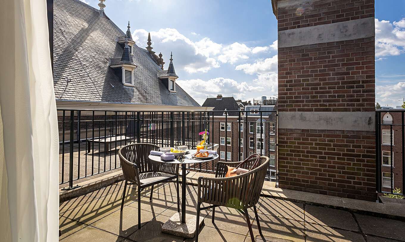 Executive Terrace room at Pestana Amsterdam Riverside has a balcony with a table with food and two chairs