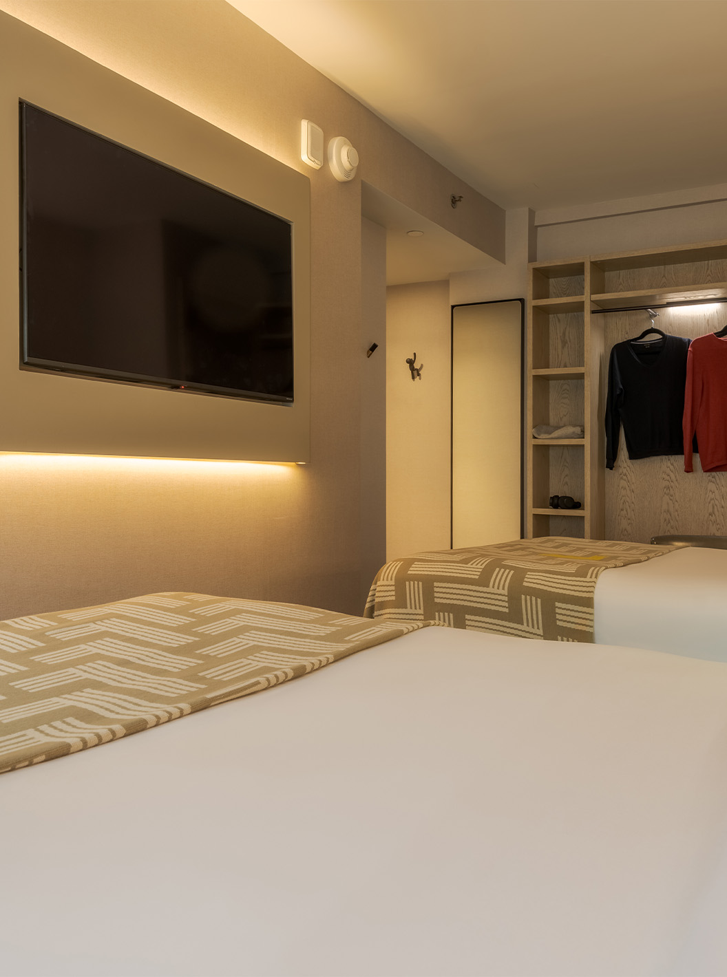 The Superior Double at Pestana CR7 Times Square has two beds with a bedspread with the number seven, a TV, and a wardrobe