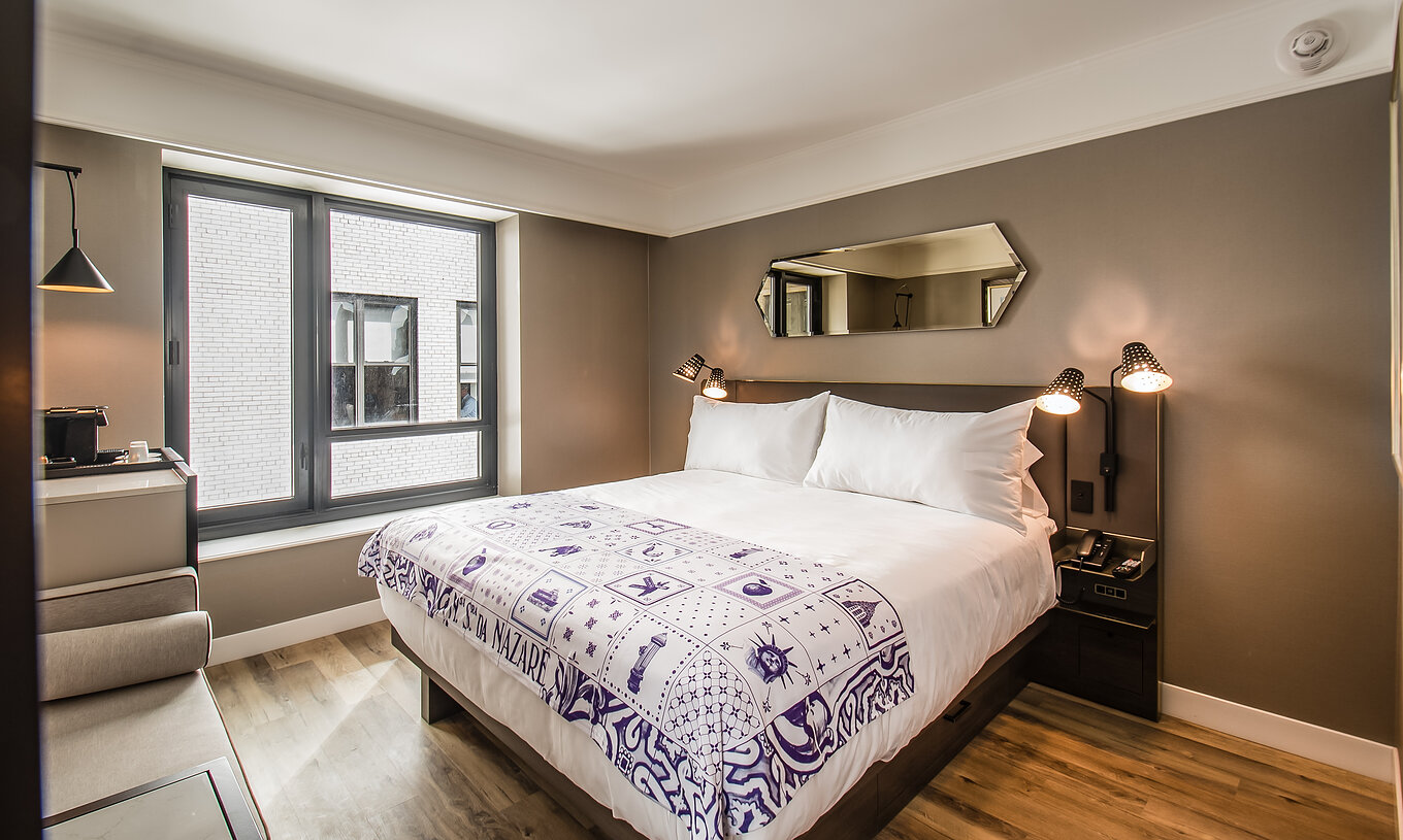 The Classic room - ADA at Pestana Park Avenue has a double bed, with a bedside table with lamp and phone