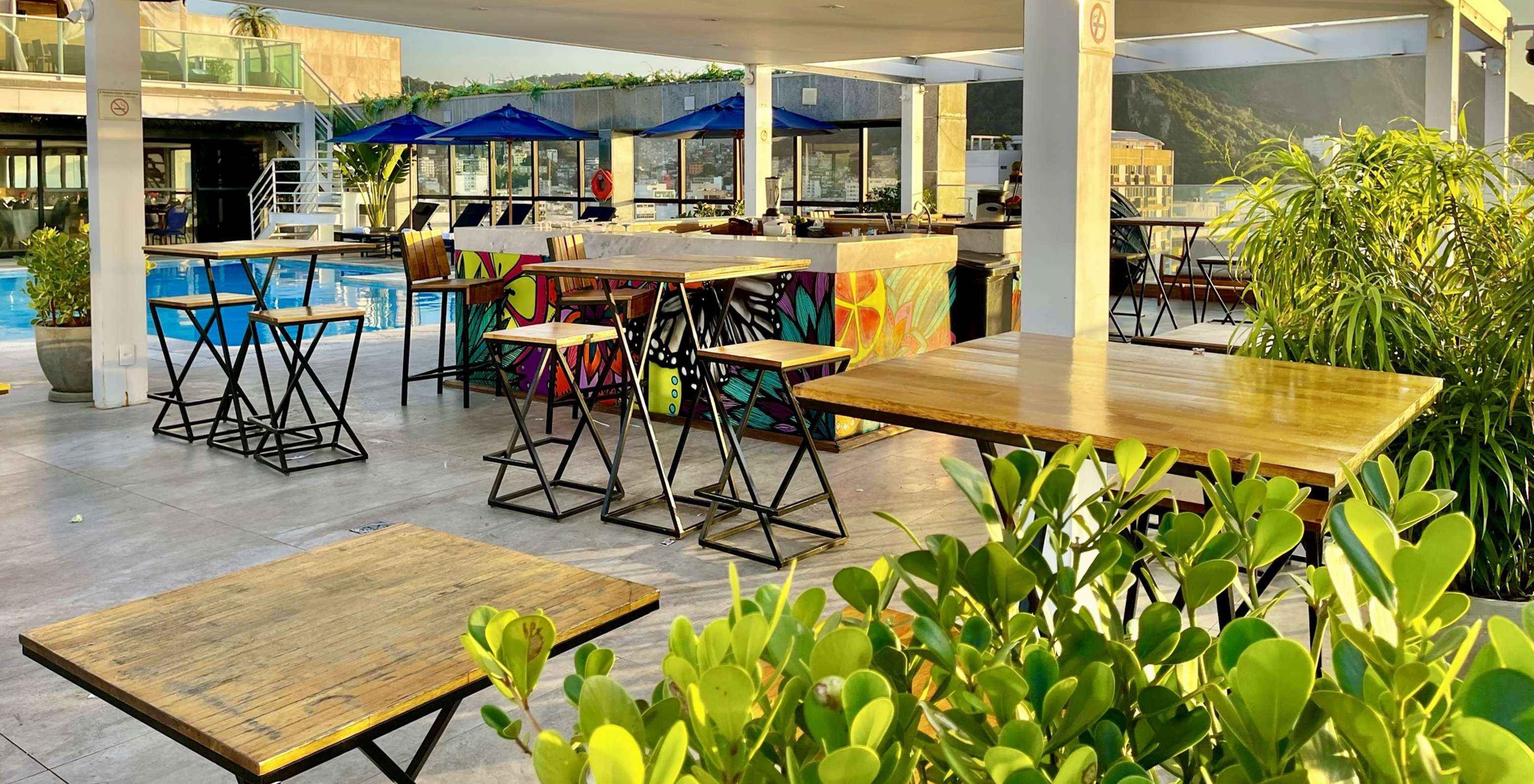 O bar Deck, do Hotel 4 Estrelas no Rio de Janeiro, tem várias mesas, espreguiçadeiras e serve bebidas ao lado da piscina