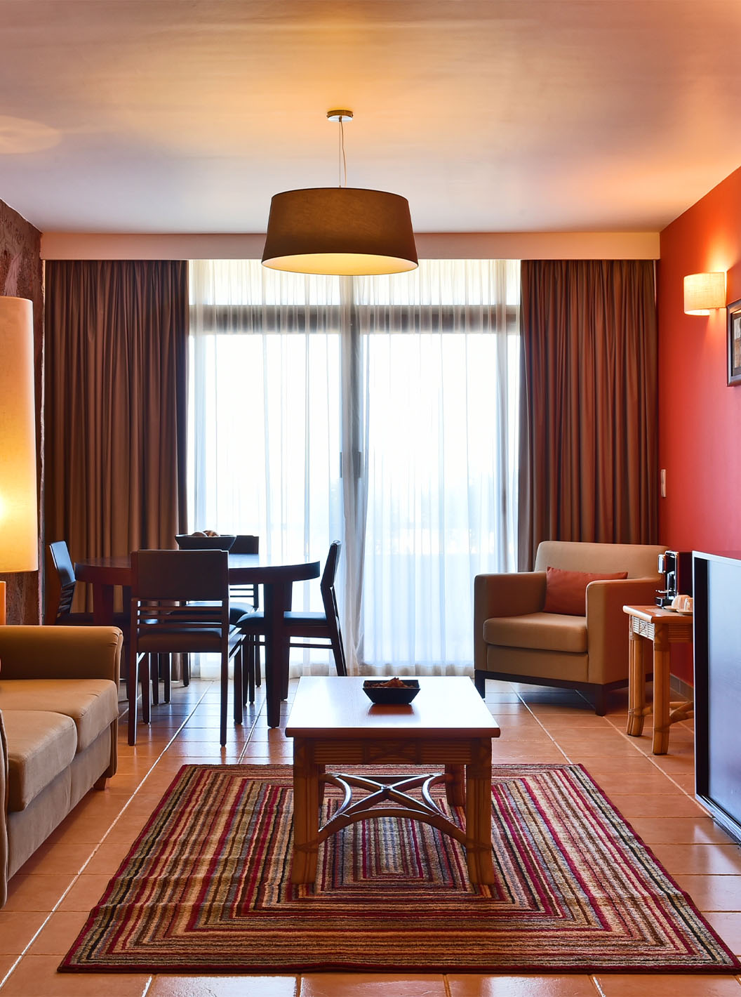 La Suite Premium del Pestana Tropico cuenta con una sala con sofá, mesa de comedor, sillón y una mesa de centro