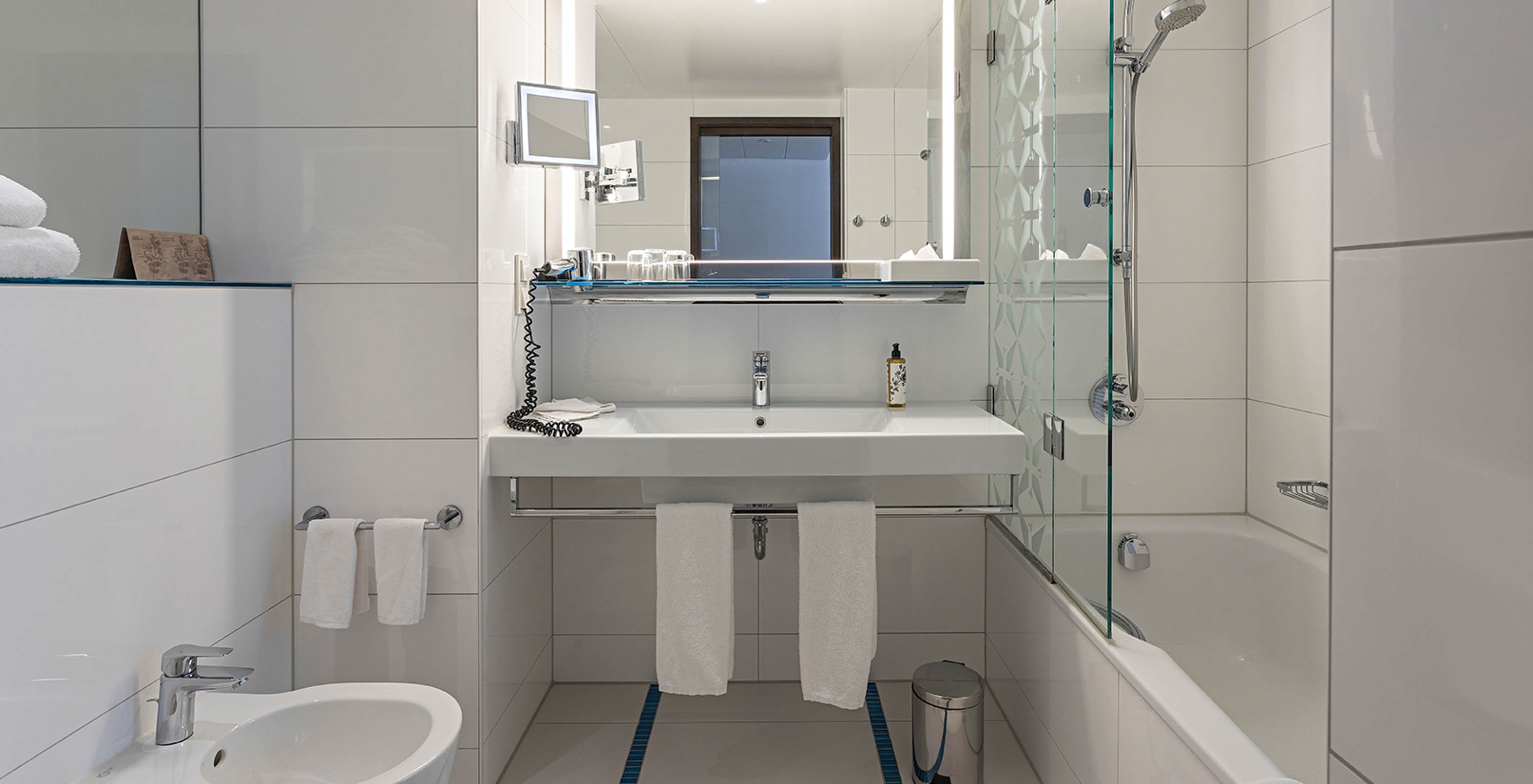 Family Deluxe con baño con bañera, ducha, lavabo y espejo.