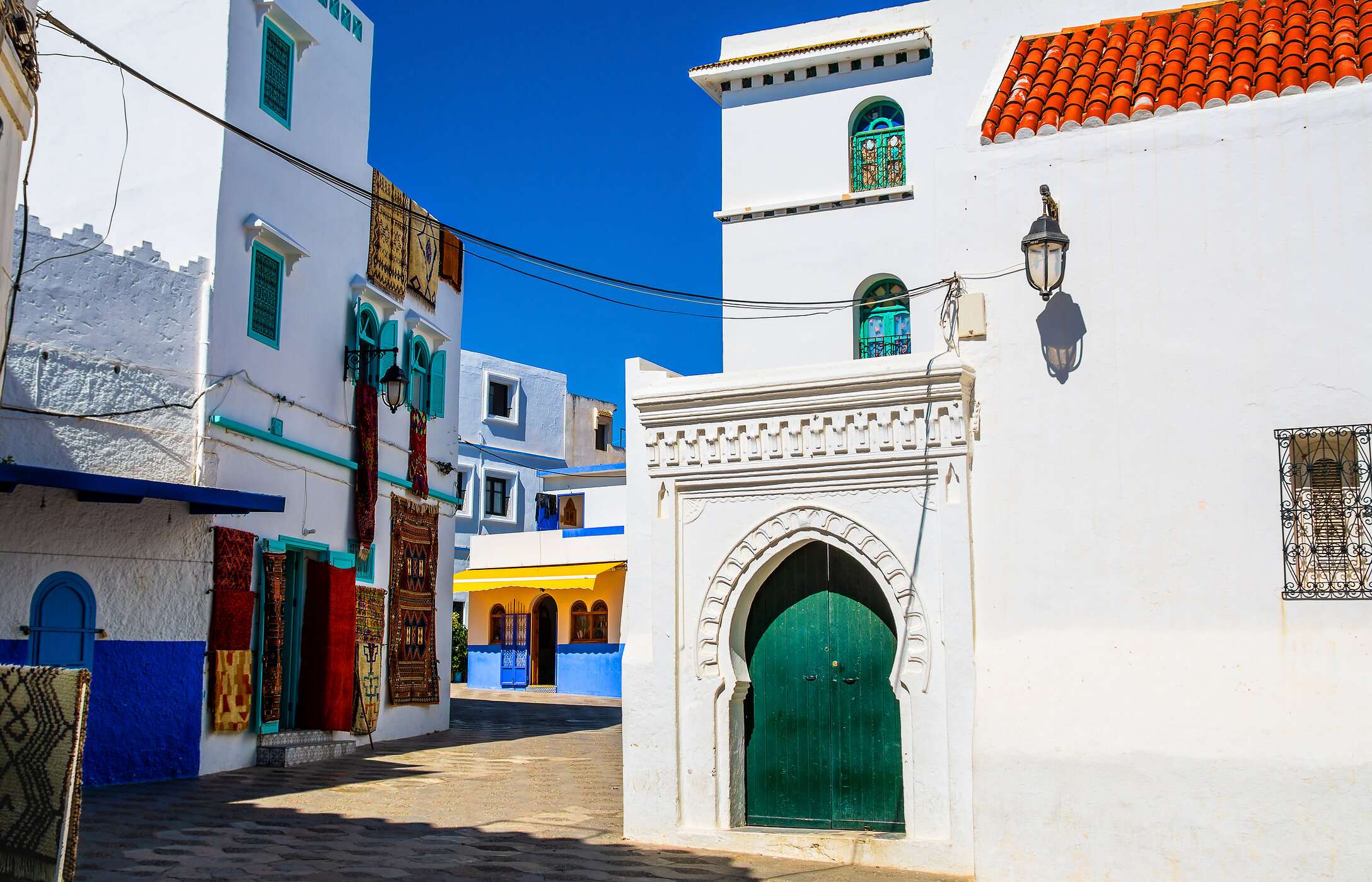 Por las estrechas calles de Tánger, es posible pasear por rincones coloridos con tapices colgantes