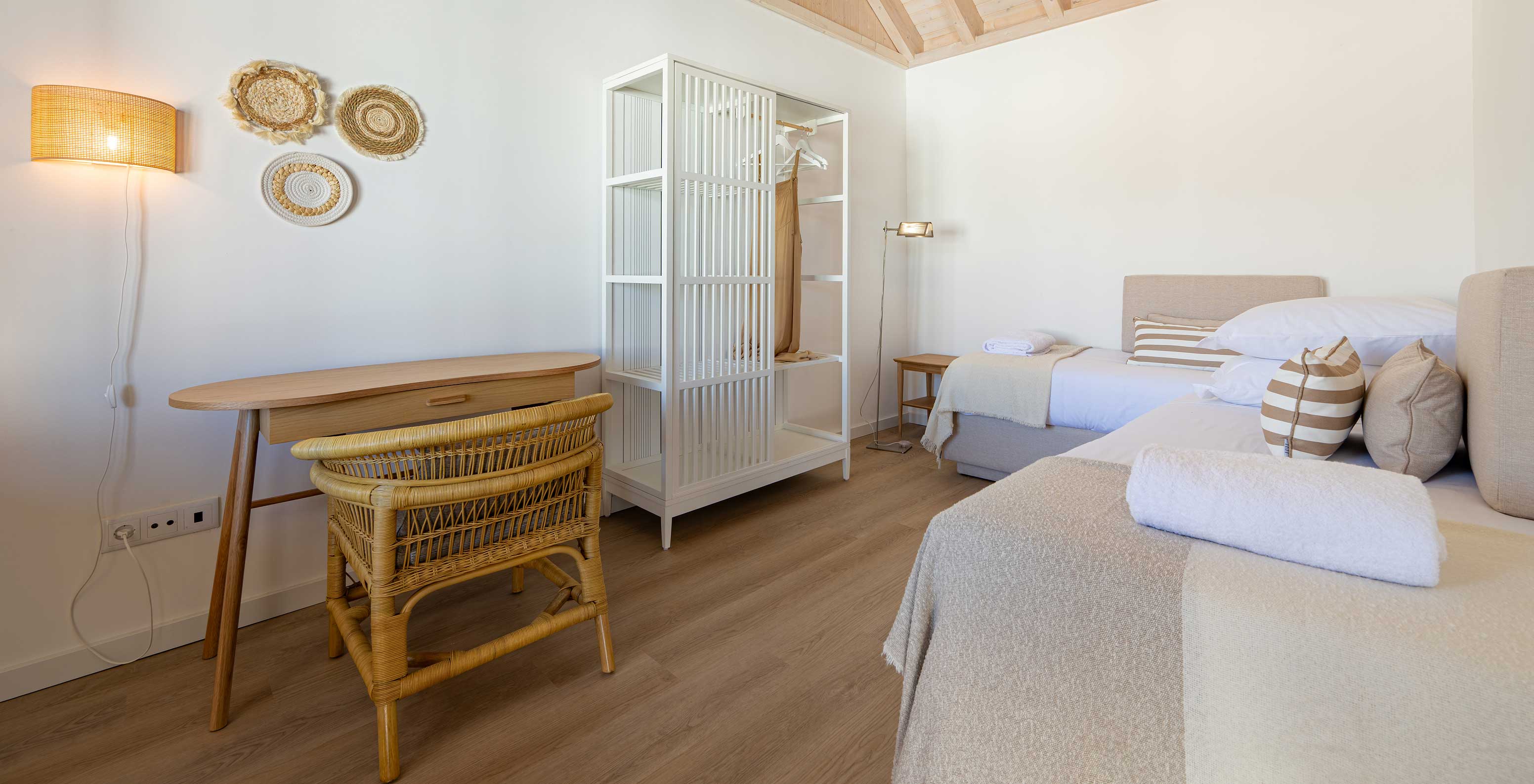 La Standard Villa de Pestana Comporta Village Residences tiene un dormitorio con cama, mesa y silla de mimbre