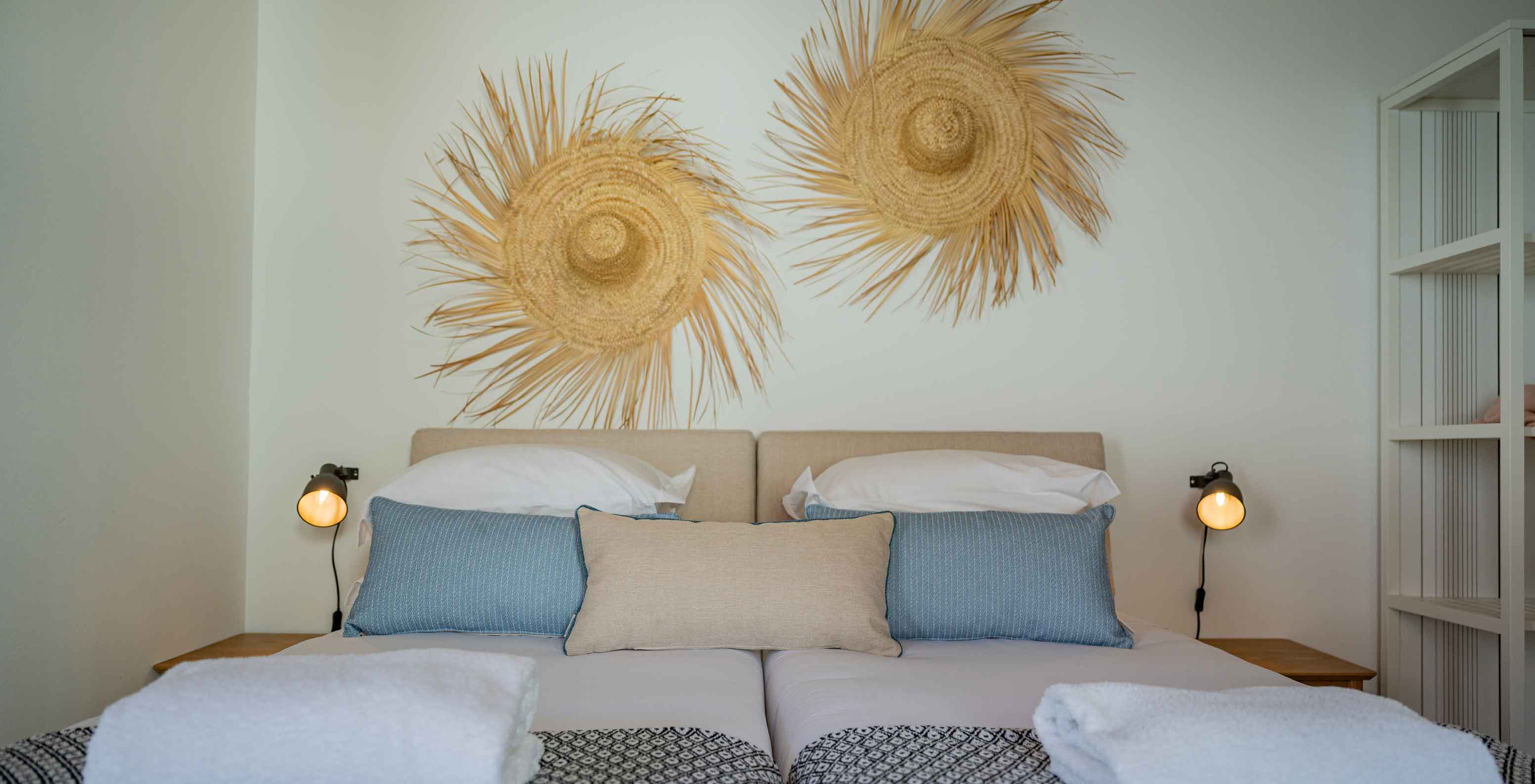La Standard Villa T2 de Pestana Comporta Village Residences tiene una cama doble con decoración de paja en la pared
