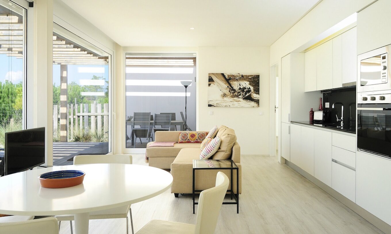 La Green Villa T3 del Pestana Tróia Eco Resort tiene una sala junta con la cocina, sofá y mesa para cenar