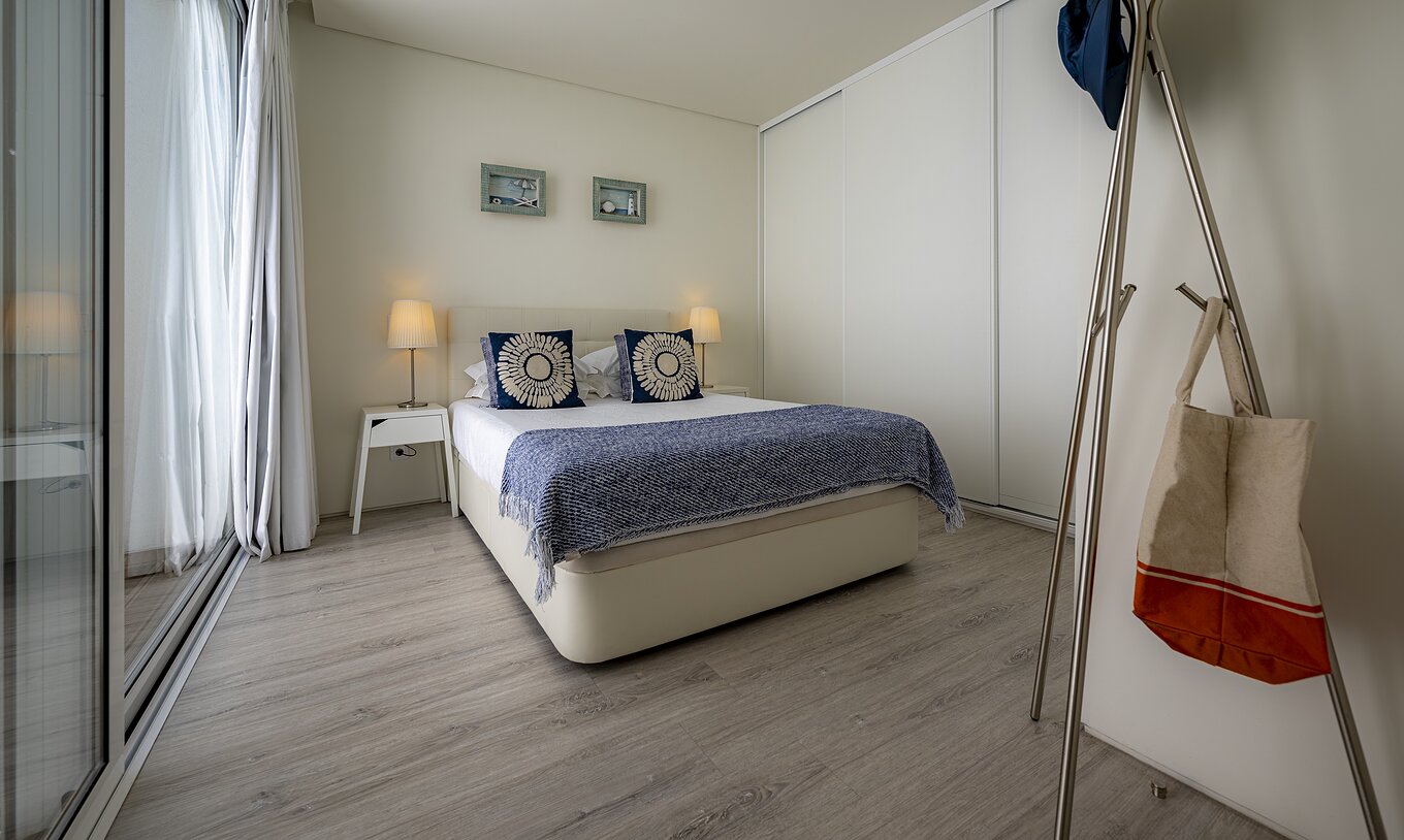 La Green Villa del Pestana Tróia Eco Resort tiene una cama de matrimonio con dos mesas de noche y un edredón azul