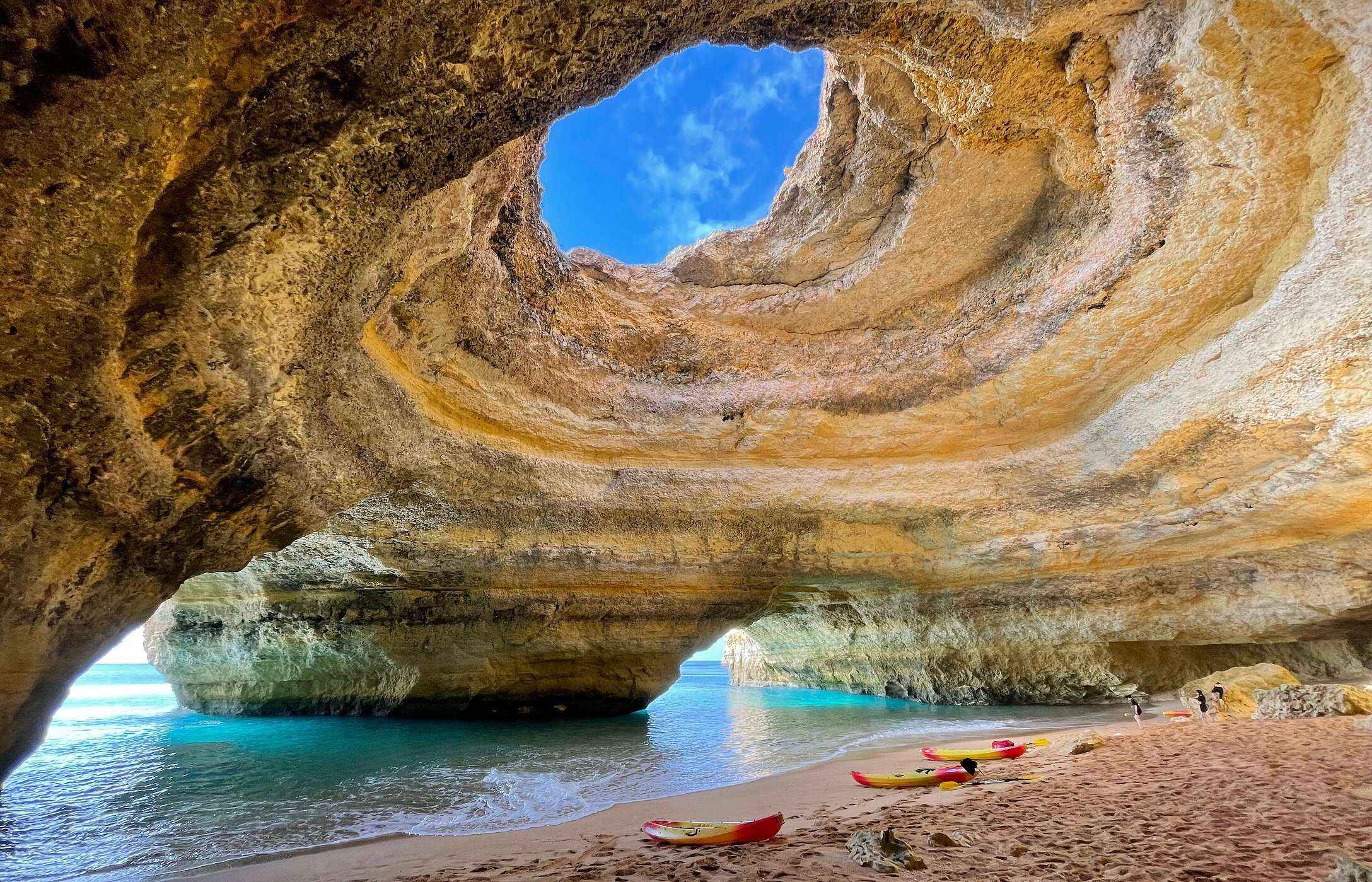 Vista interior de la Gruta de Benagil, en el Algarve, con una abertura en el techo que permite la entrada de luz natural