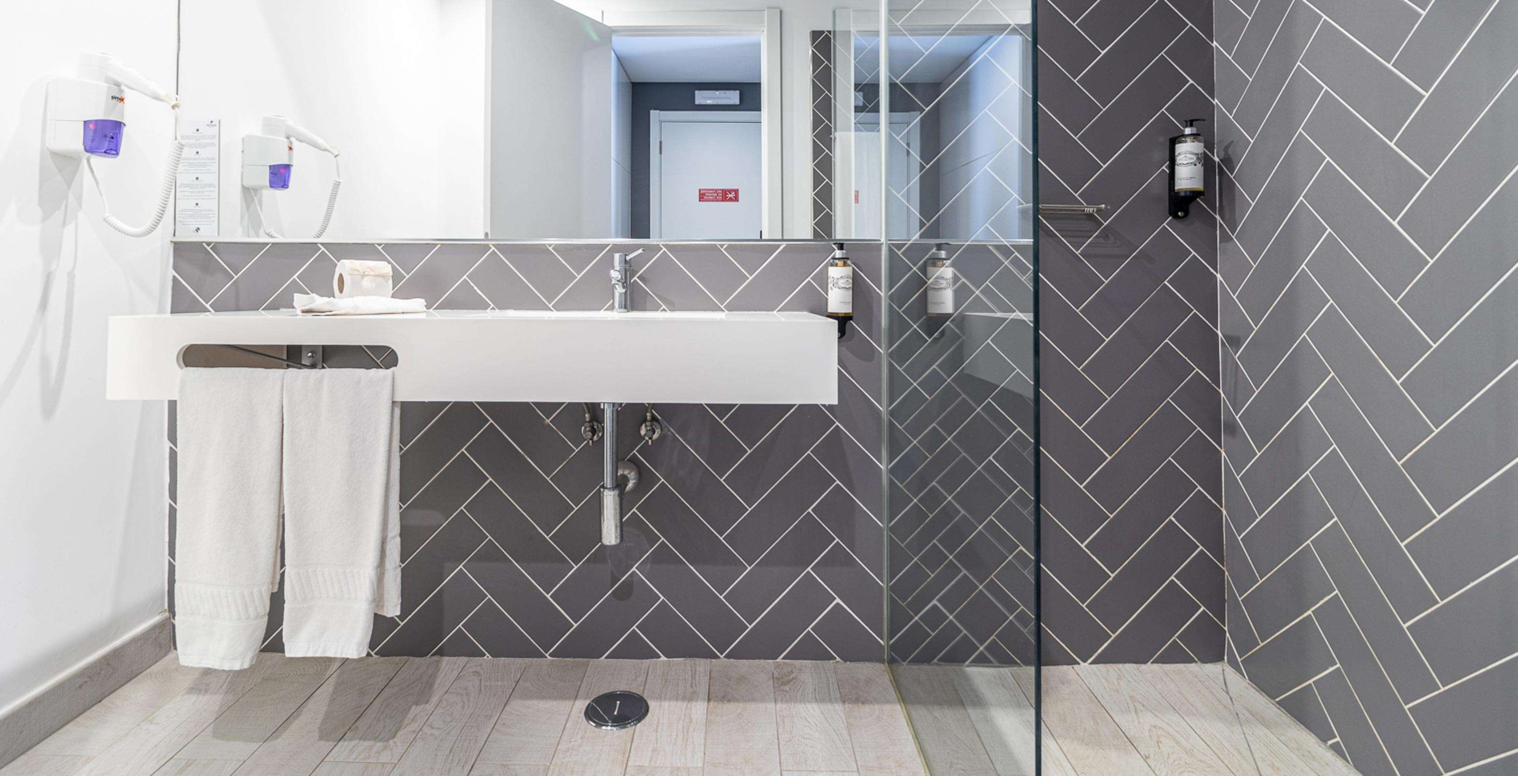 Habitación Clásica en Pestana Gramacho Residences con baño moderno, lavabo blanco, espejo y ducha de vidrio