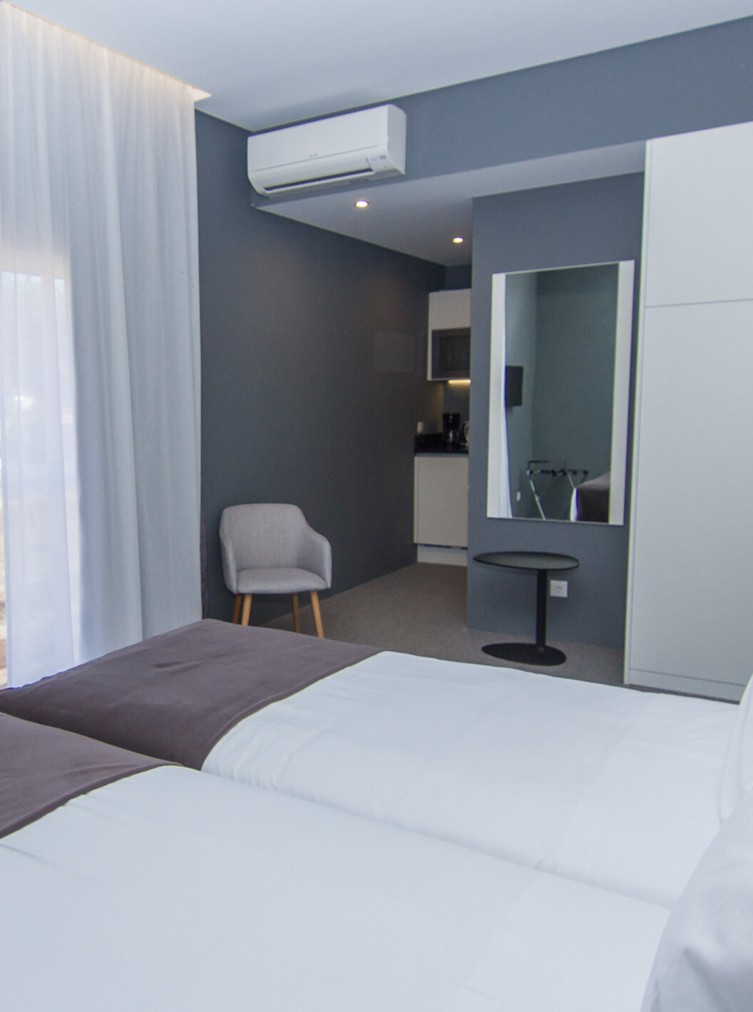 El Cuarto Clásico del Pestana Gramacho Residences tiene dos camas individuales, aire acondicionado, una ventana y un espejo