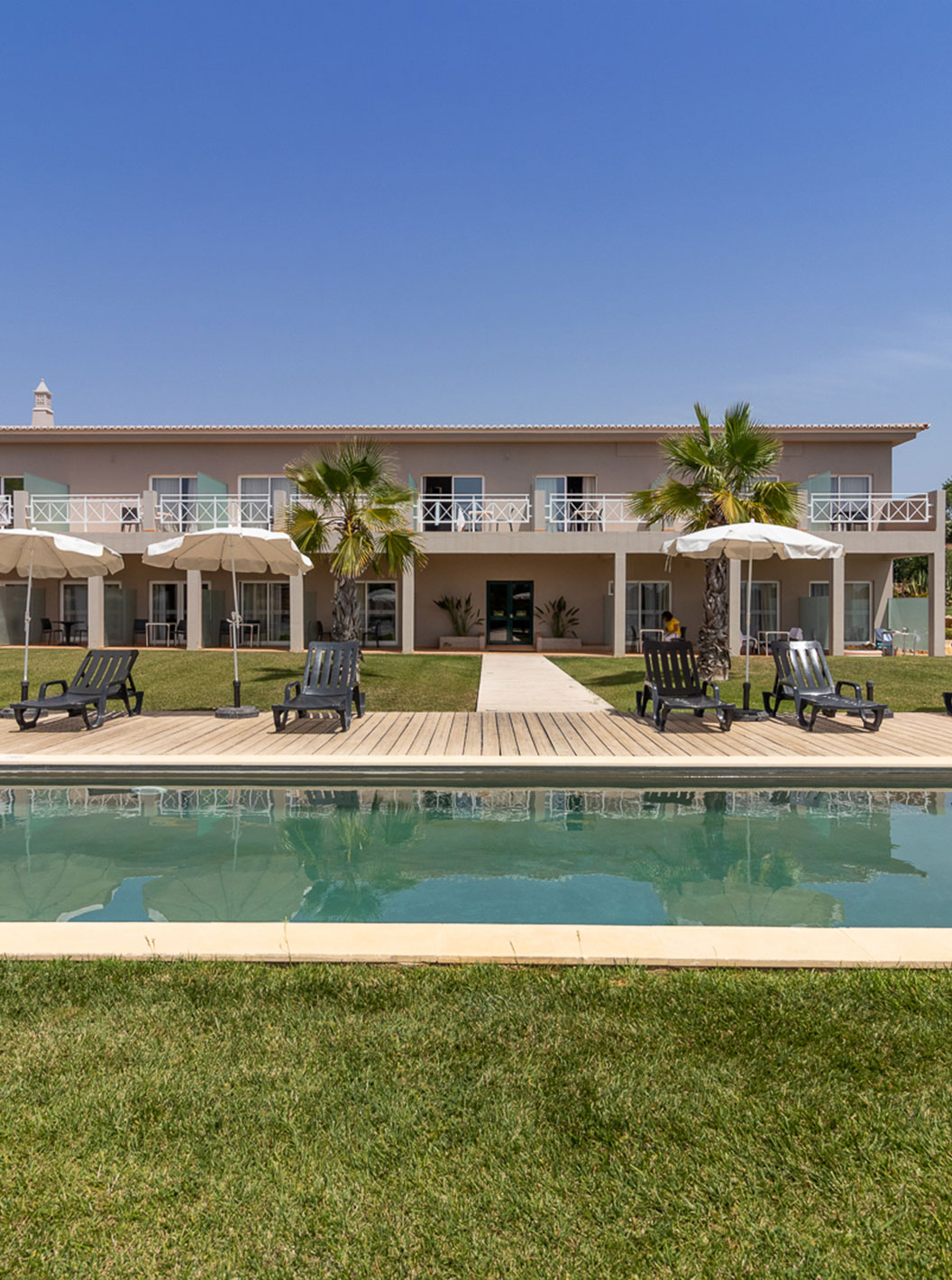 Habitación Clásica en Pestana Gramacho Residences con piscina, tumbonas y sombrillas en jardín cuidado