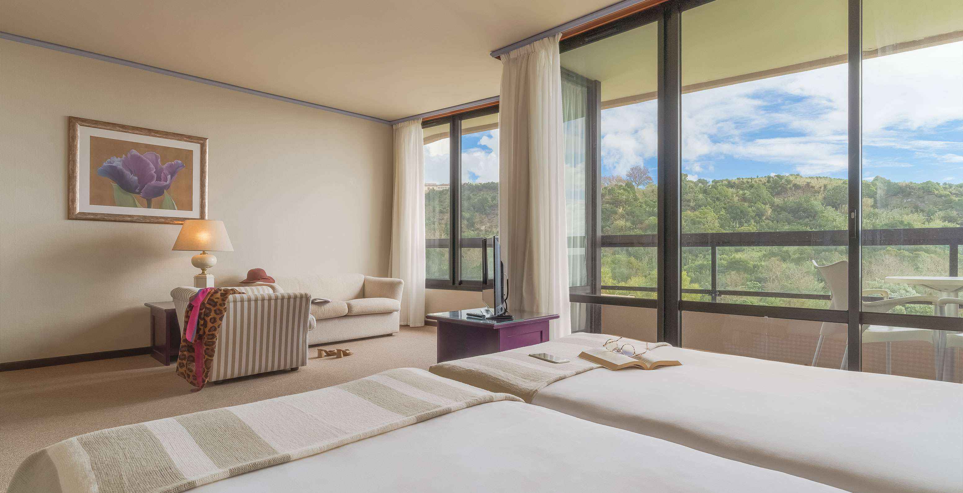 La Junior Suite Vista Jardín del Pestana Bahia Praia tiene hermosa vista a la naturaleza verde, con acceso al balcón