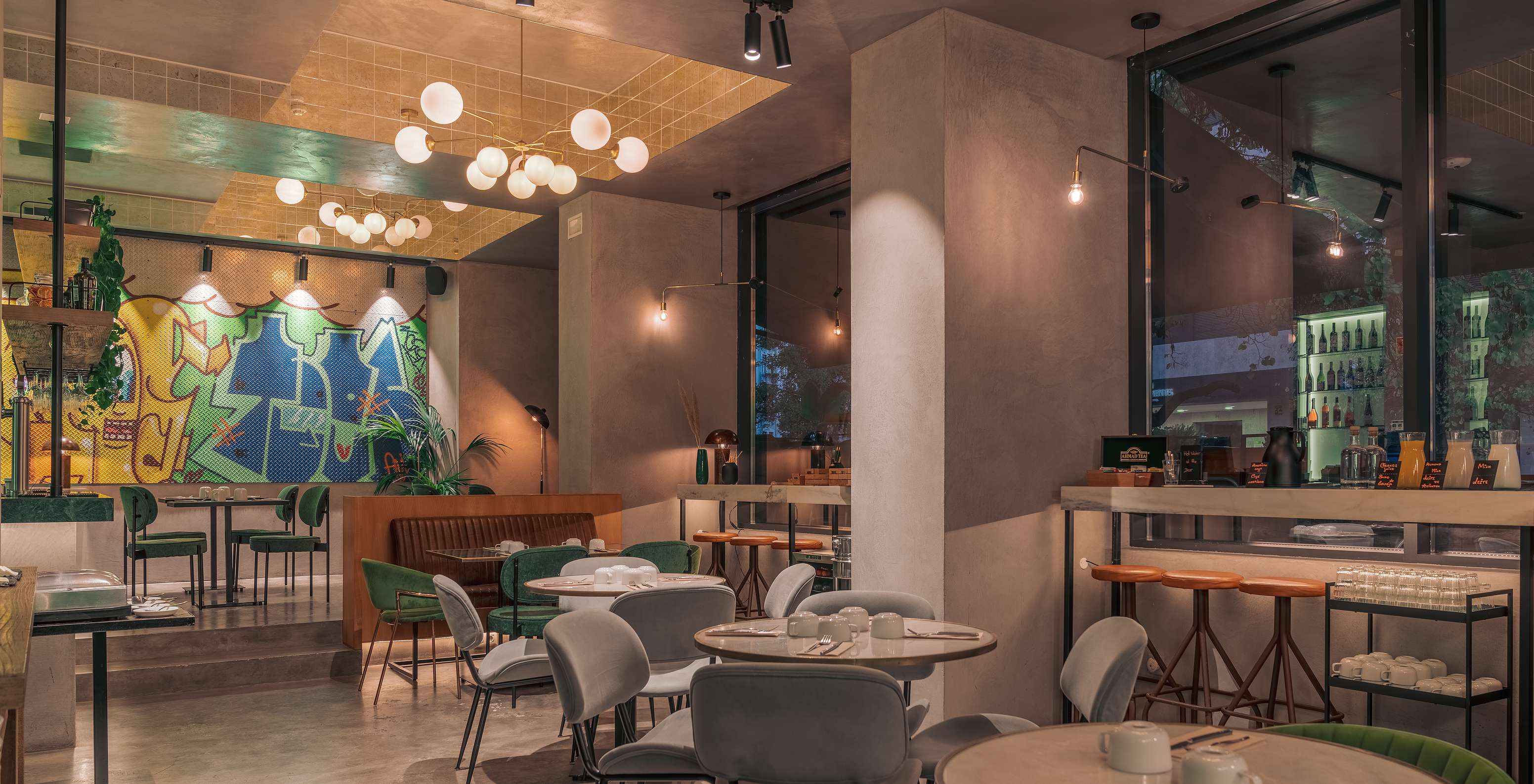 Restaurante del Pestana Lisboa Vintage con mesas y sillas coloridas, lámparas de techo y mostradores altos con sillas