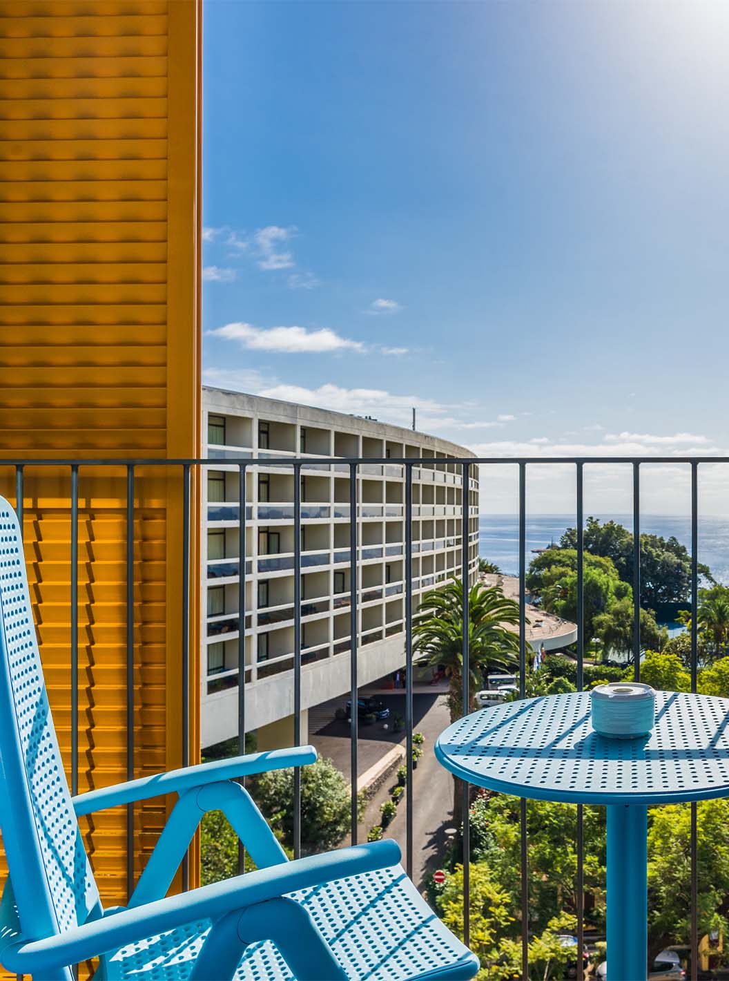 El Estudio Deluxe Vista Mar del Pestana Casino Studios tiene una terraza con vista a la ciudad y una mesa con sillas azules