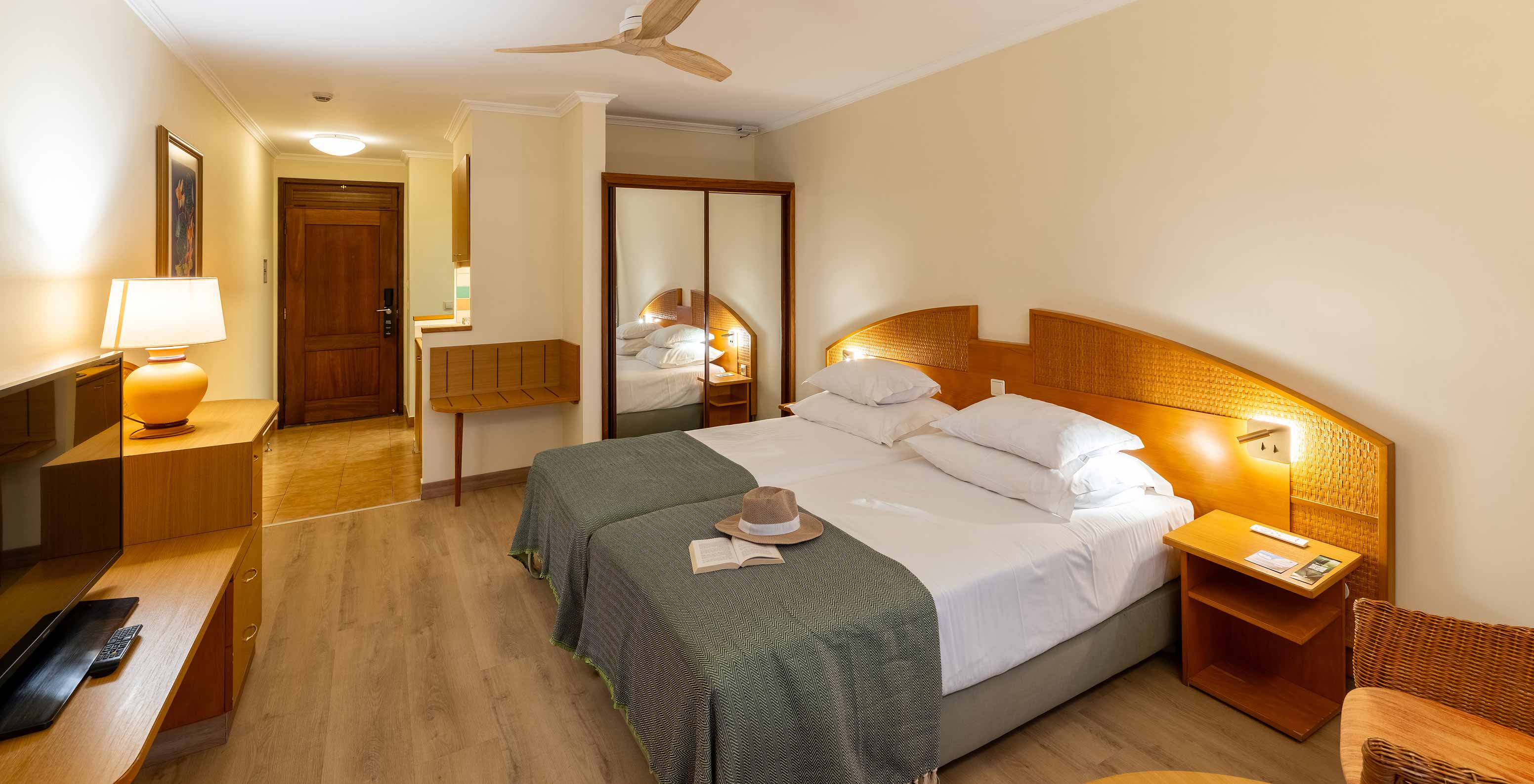 El Classic Pool View del Pestana Ocean Bay All Inclusive tiene dos camas individuales unidas con una colcha verde