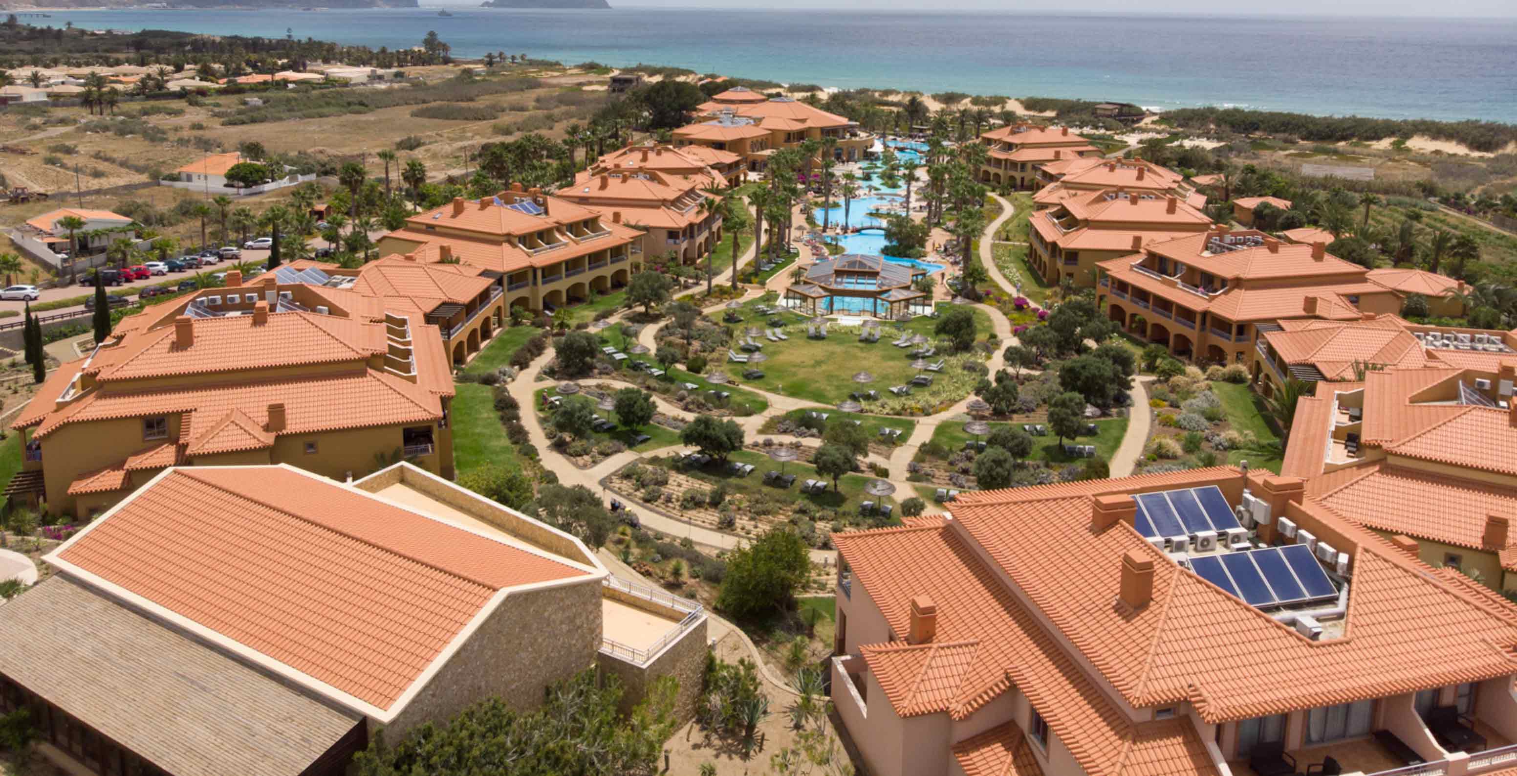 Vista de dron del Pestana Porto Santo All Inclusive, con varias villas alrededor de la piscina y la vegetación