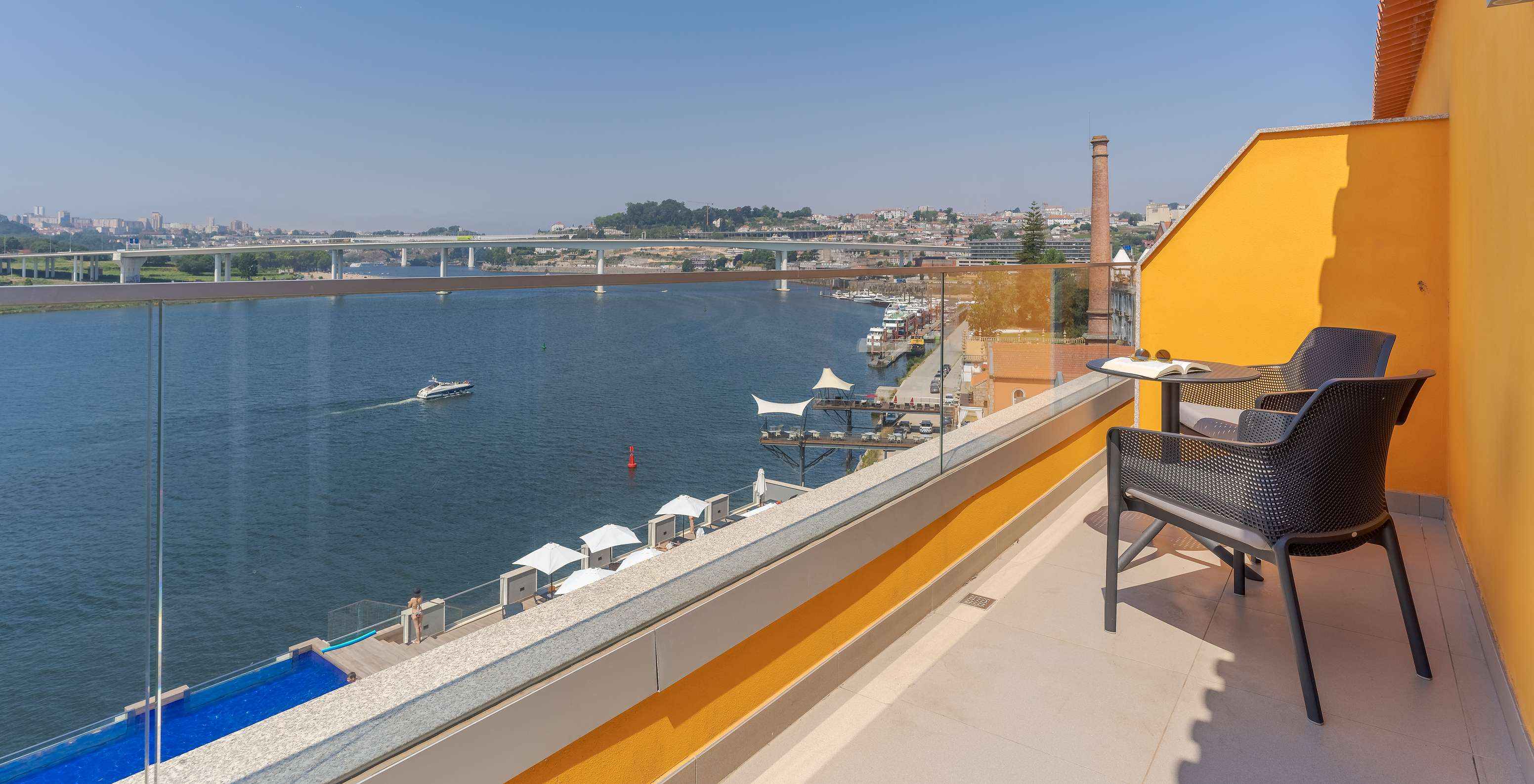 La Junior Suite del Pestana Douro Riverside cuenta con una terraza con vista al Río Douro, y mesa con sillas