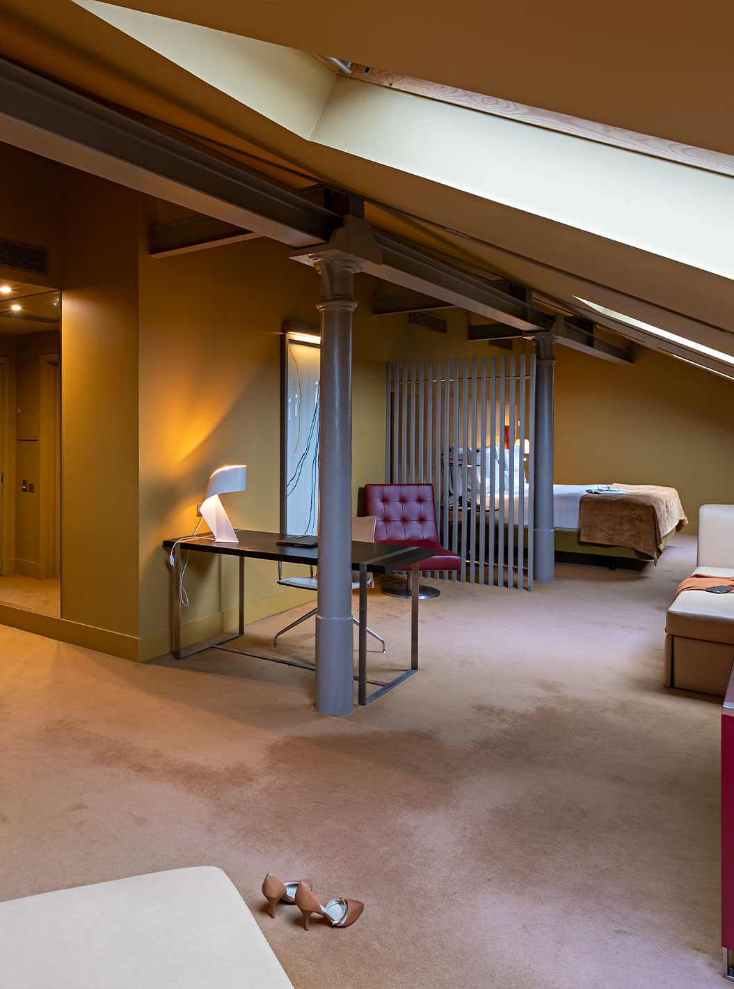 El Loft Ático del Pestana Palácio do Freixo tiene sofá beige de piel, escritorio y mueble rojo