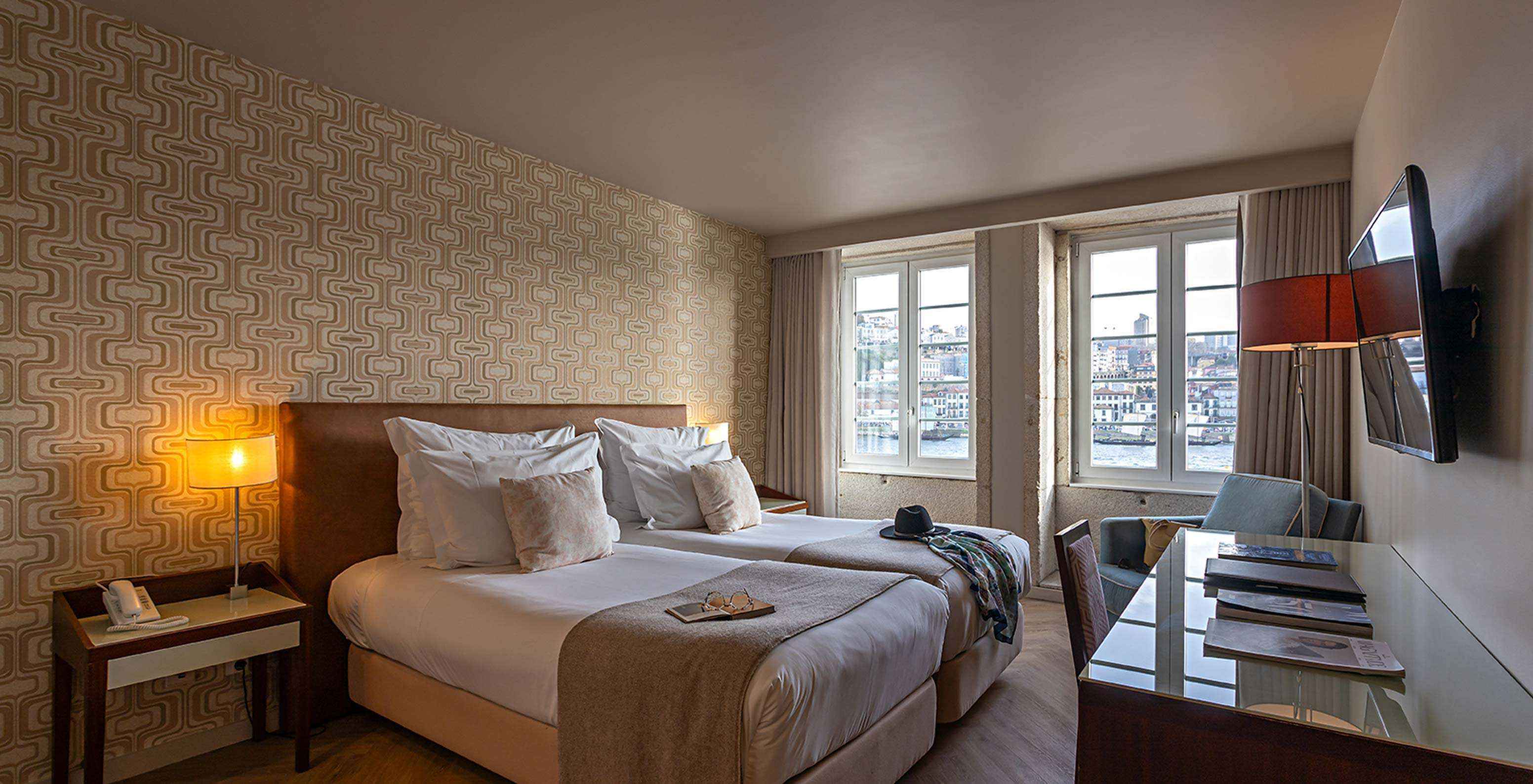 El Vintage River View del Pestana Vintage Porto tiene dos camas individuales, papel tapiz en tonos arena y dos ventanas