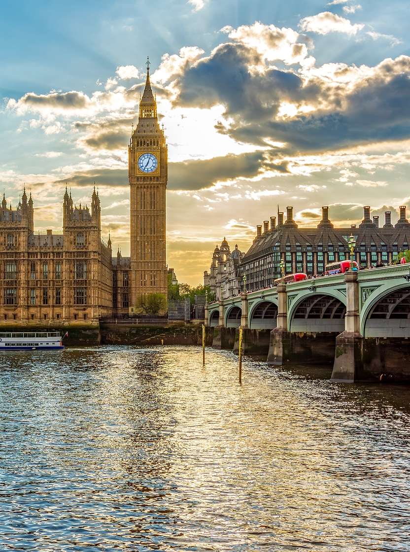 Vista panorámica del Palacio de Westminster, en Londres, junto al emblemático Big Ben, con el río Támesis en primer plano.