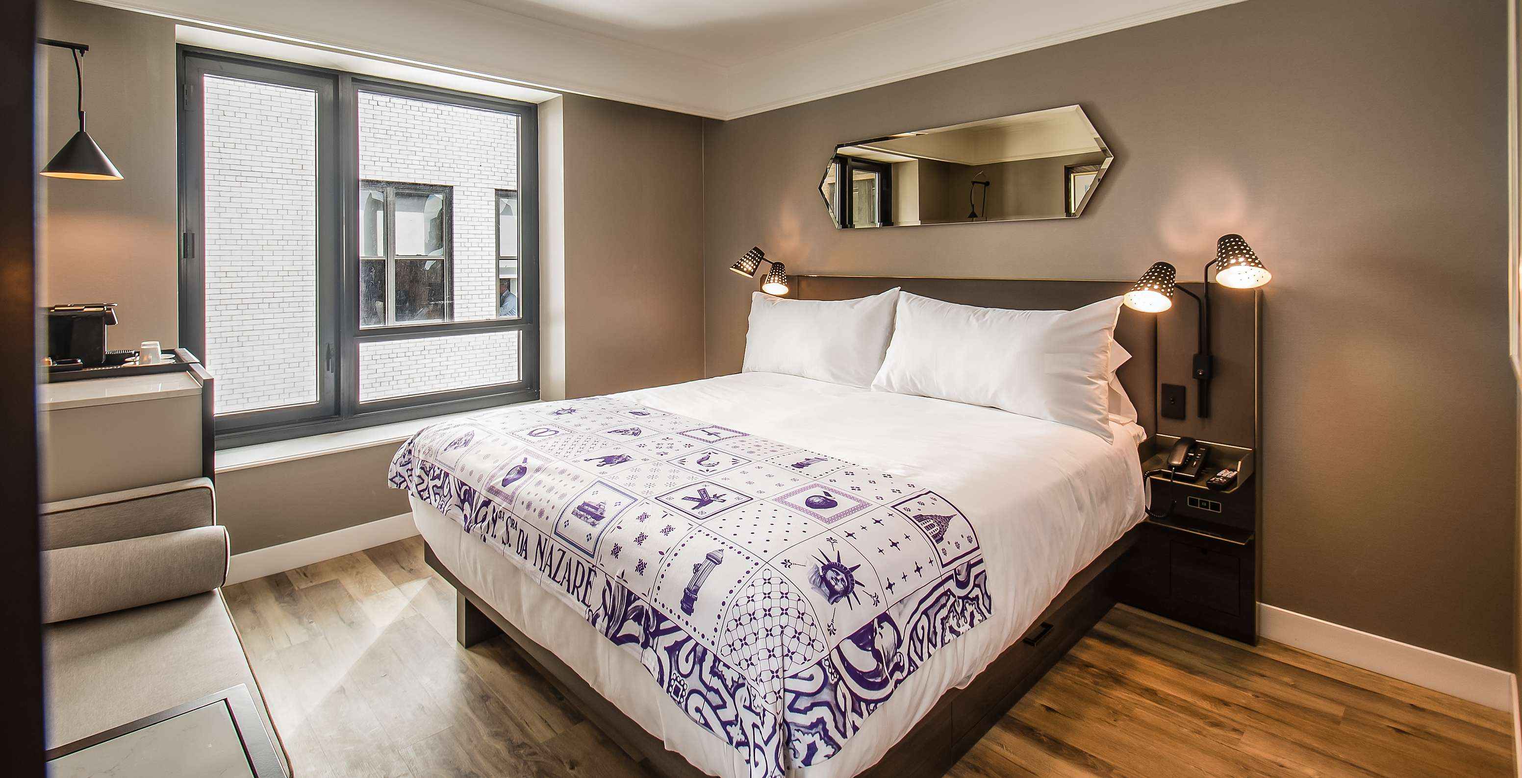 La habitación Clásica del Pestana Park Avenue cuenta con una cama de casal, con mesa de noche con lámpara y teléfono