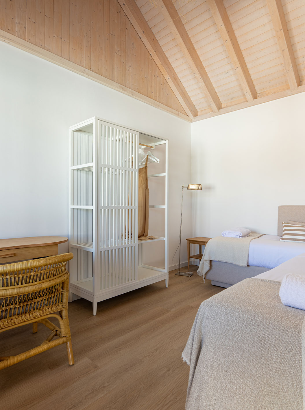 La Standard Villa de Pestana Comporta Village Residences tiene un dormitorio con cama, mesa y silla de mimbre