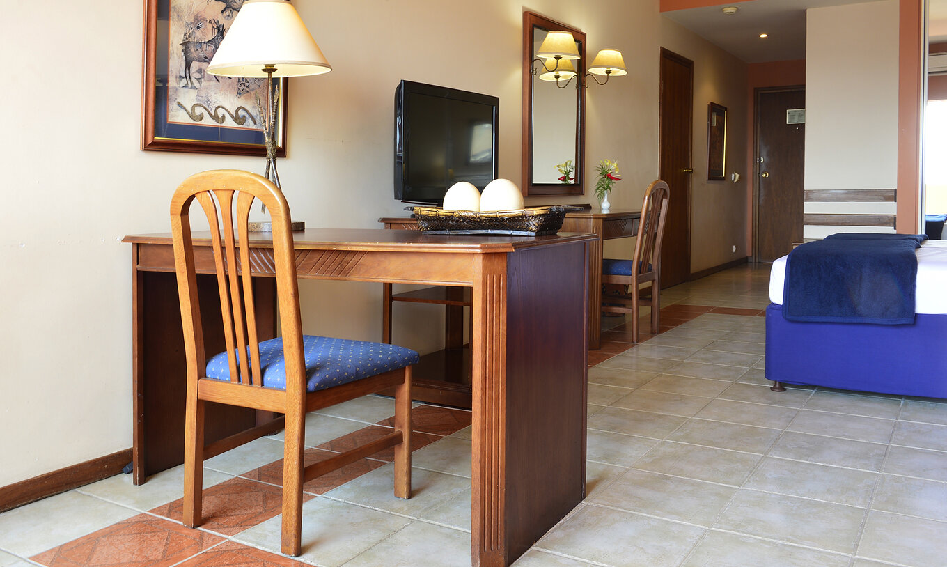 De Familiale Executive Suite van Pestana Rovuma heeft een bureau en houten stoel, met lamp en schilderij