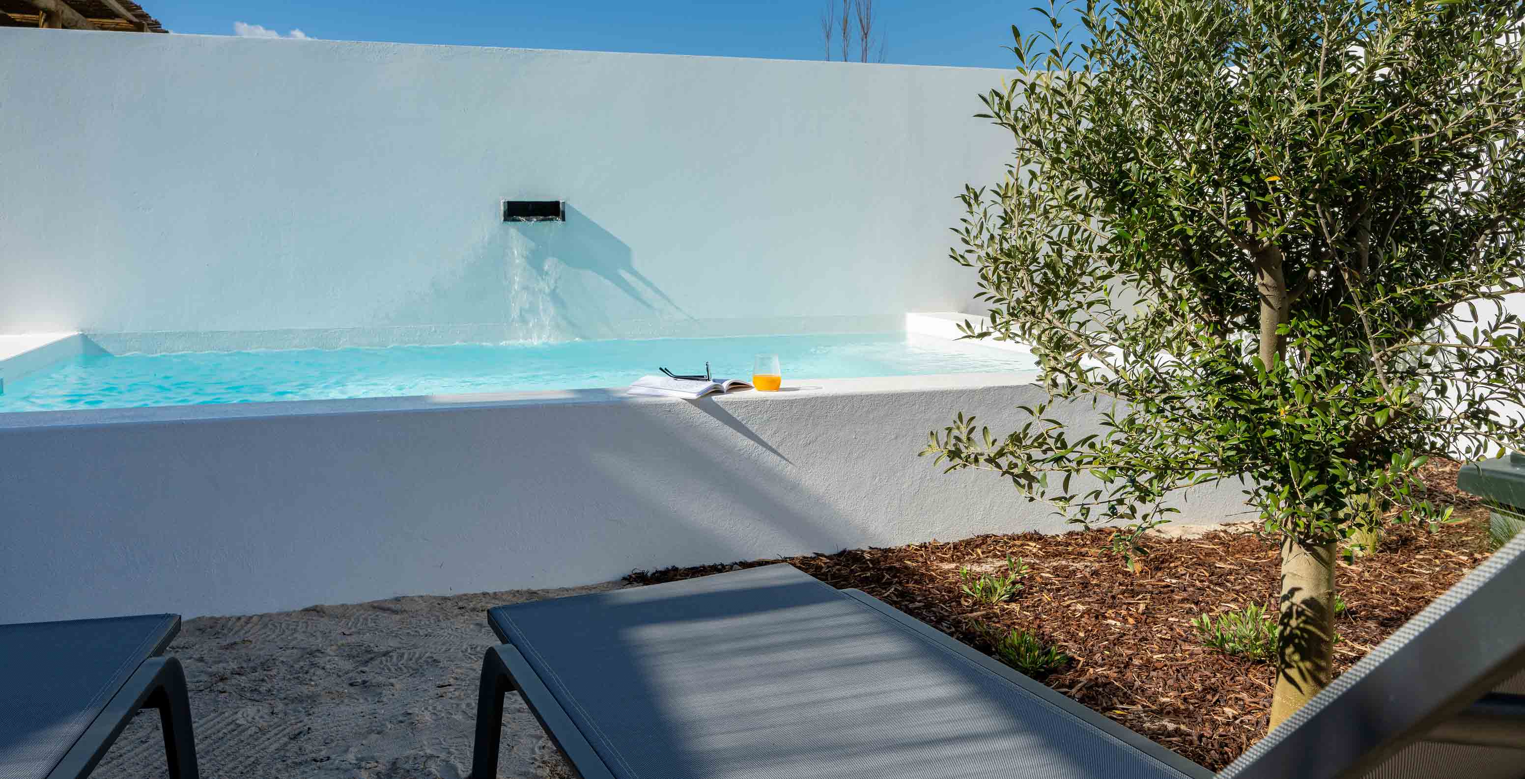De Superieure Villa bij Pestana Comporta Village Residences heeft een zwembad met een waterval en meerdere ligstoelen