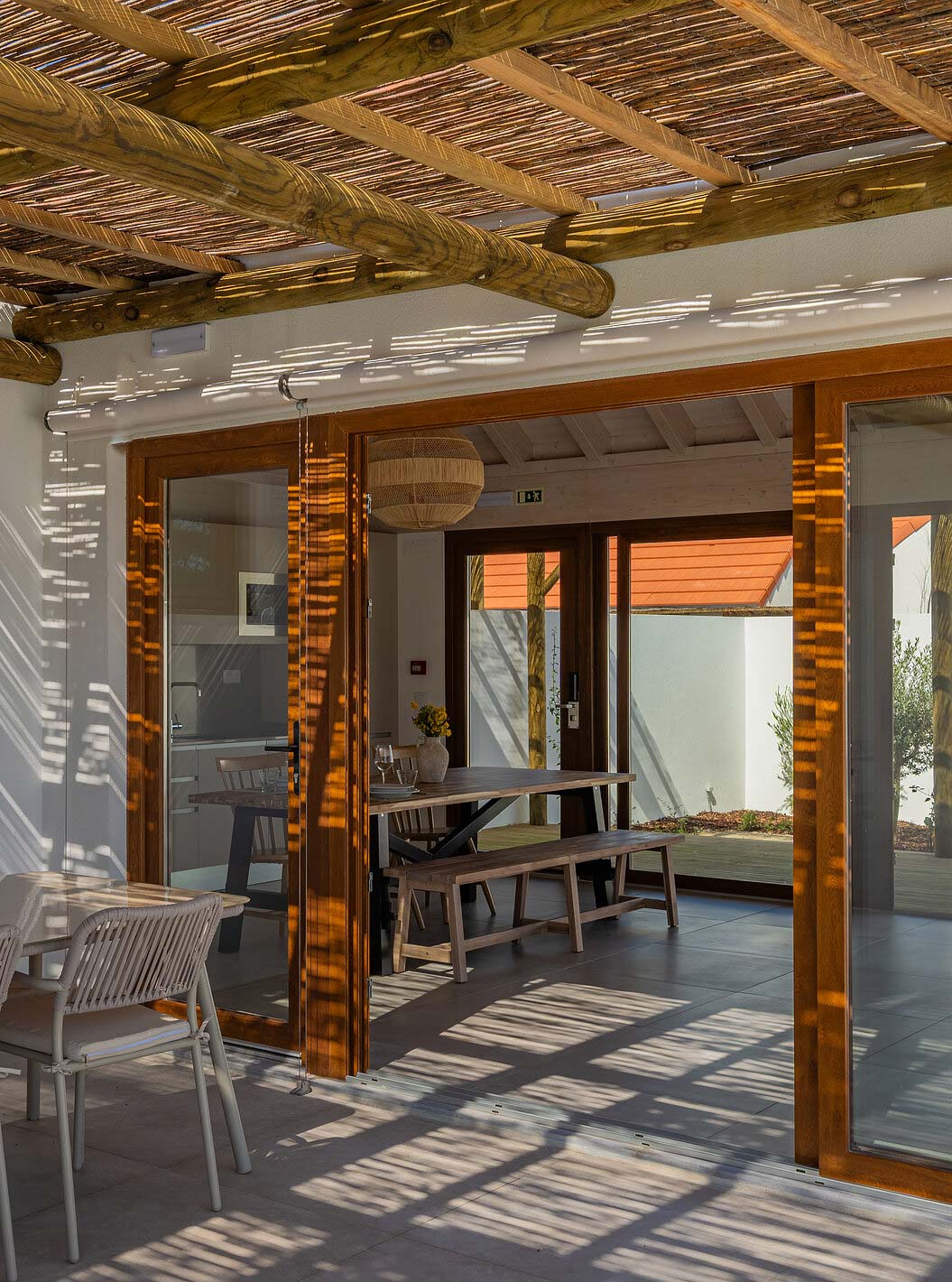 De Premium Groene Villa bij Pestana Comporta Village Residences heeft een overdekte patio met een tafel die naar binnen leidt