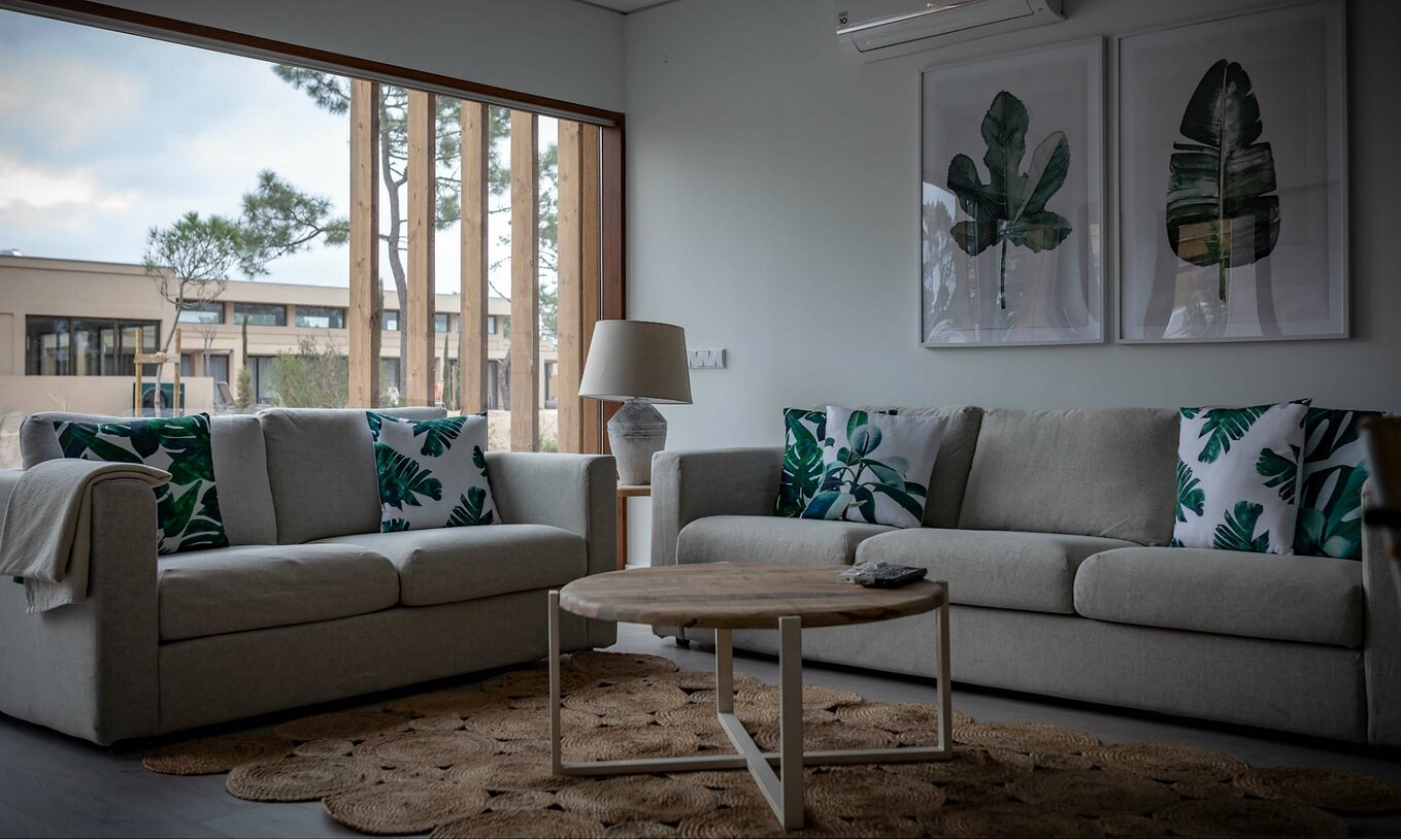 Het Eco Village Appartement Begane Grond van Pestana Tróia Eco Resort heeft een woonkamer met twee banken en een tafel