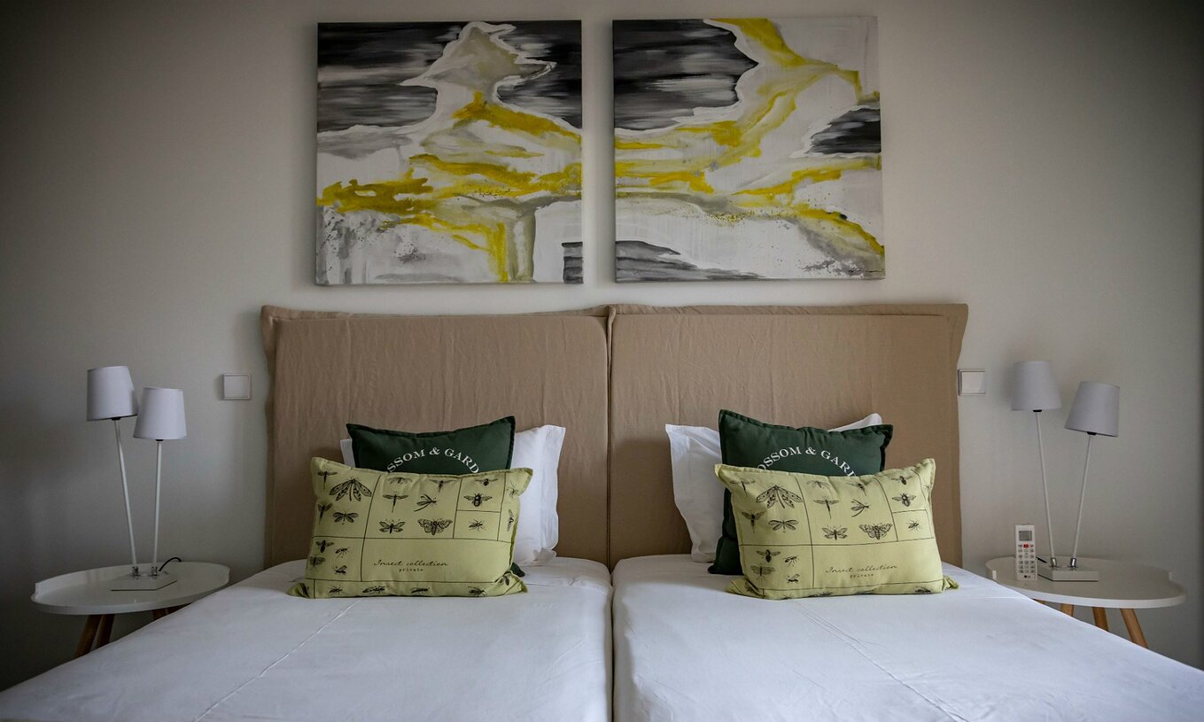 Het Eco Village Appartement Begane Grond van Pestana Tróia Eco Resort heeft twee bedden en schilderijen aan de muur
