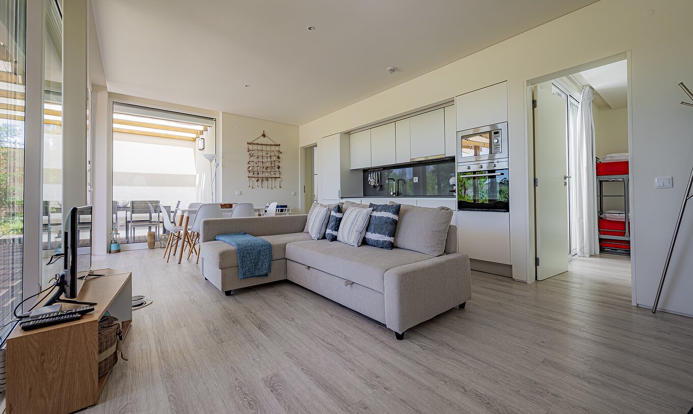 De Green Villa van Pestana Tróia Eco Resort heeft een gecombineerde woonkamer met keuken, bank, eettafel en televisie