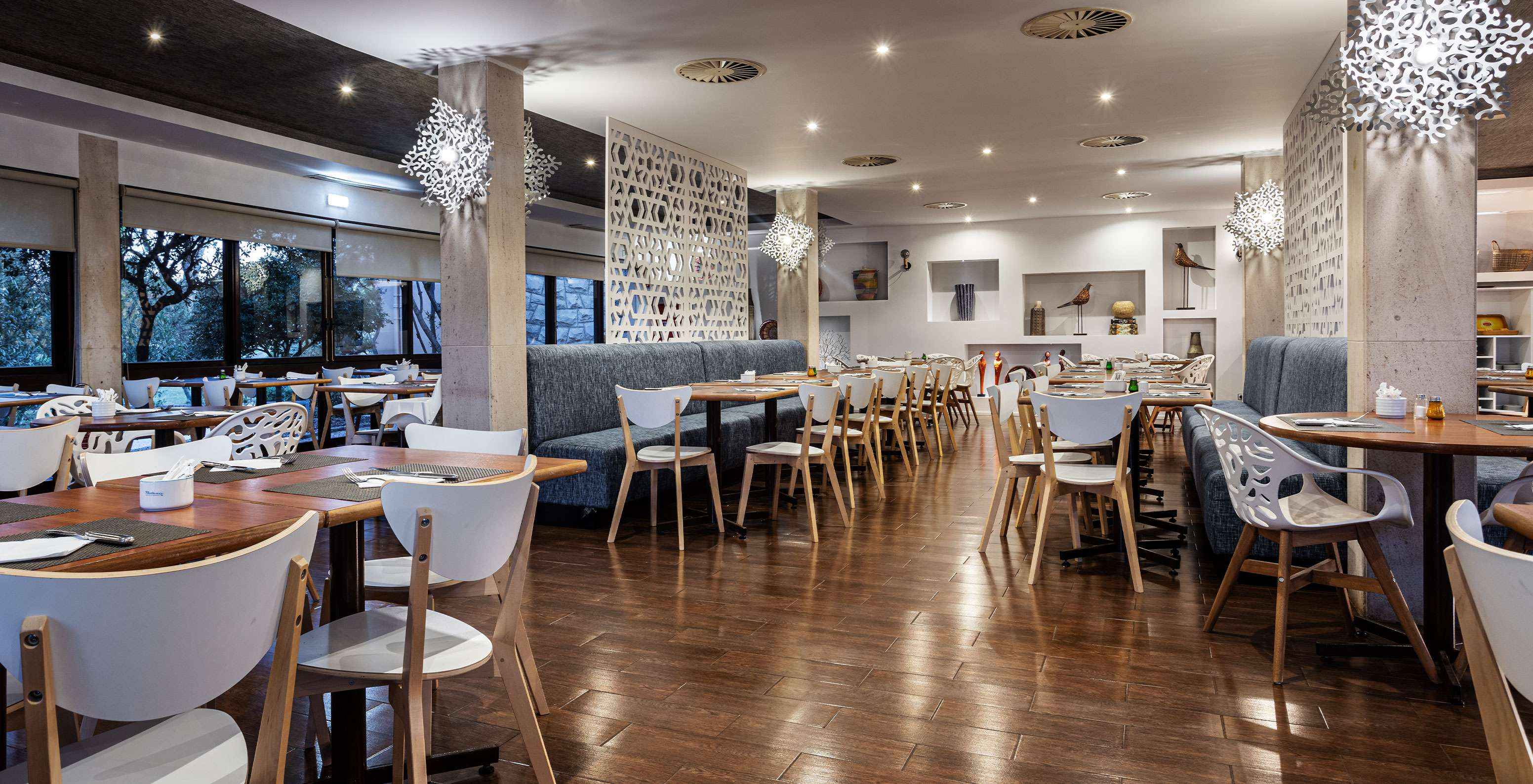 Ruim restaurant met verschillende tafels, stoelen en banken om van een maaltijd te genieten