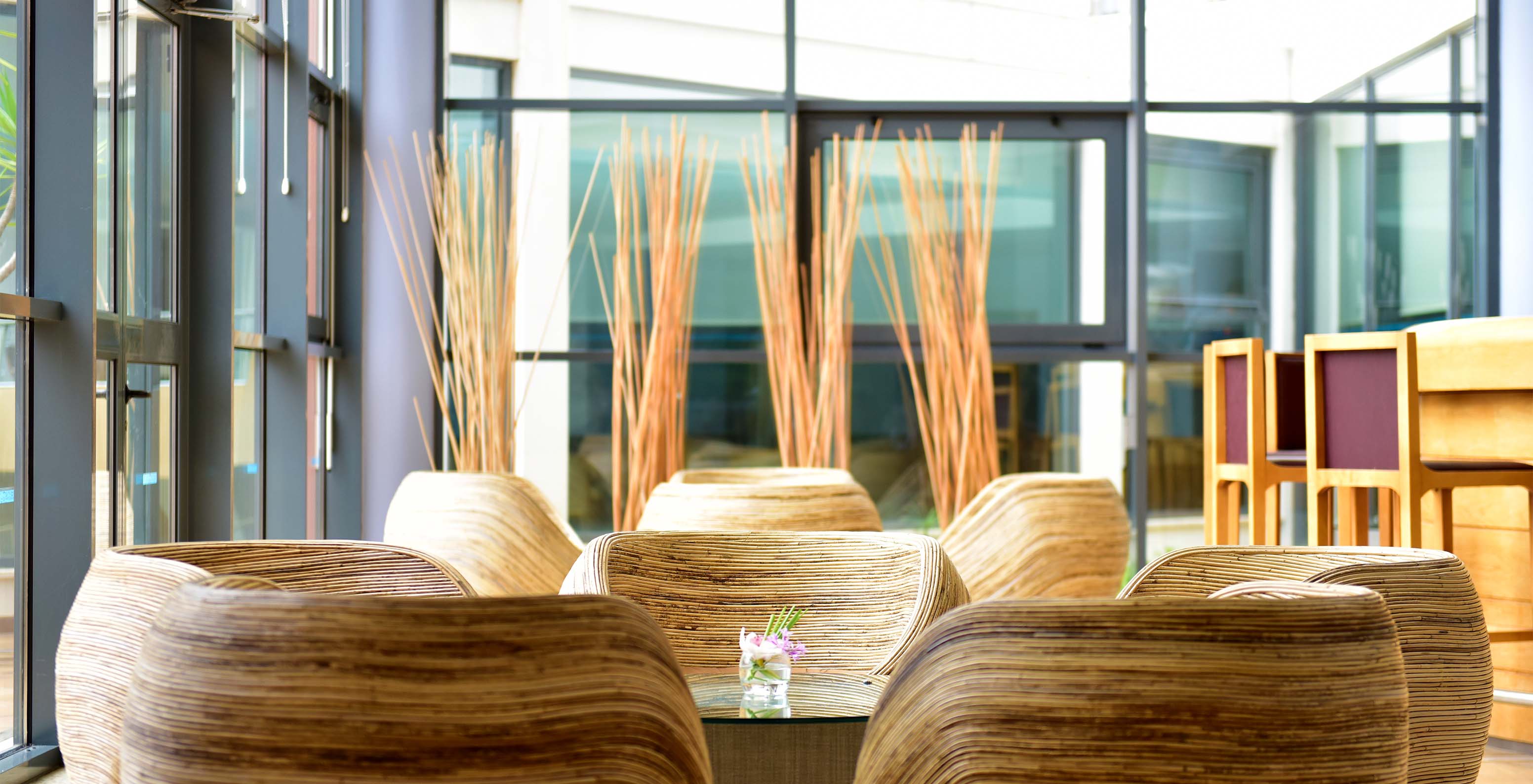 De bar A Adega, van het Aparthotel in de Algarve, heeft ronde stoelen met centrale tafels en een bar met glazen deuren