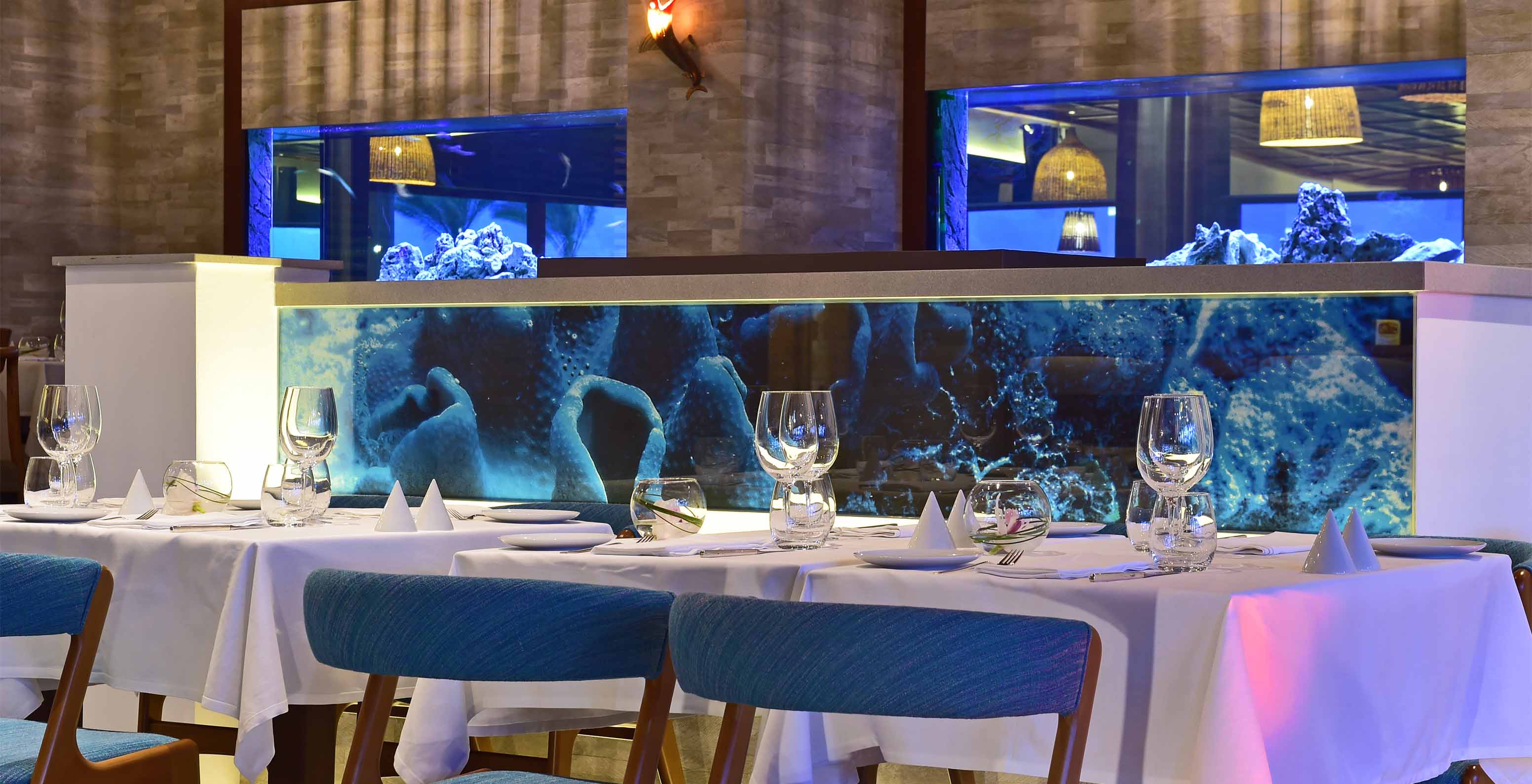 Het restaurant Sul, van het 5-sterrenhotel in de Algarve, heeft aquaria tussen de zones en gestoffeerde stoelen