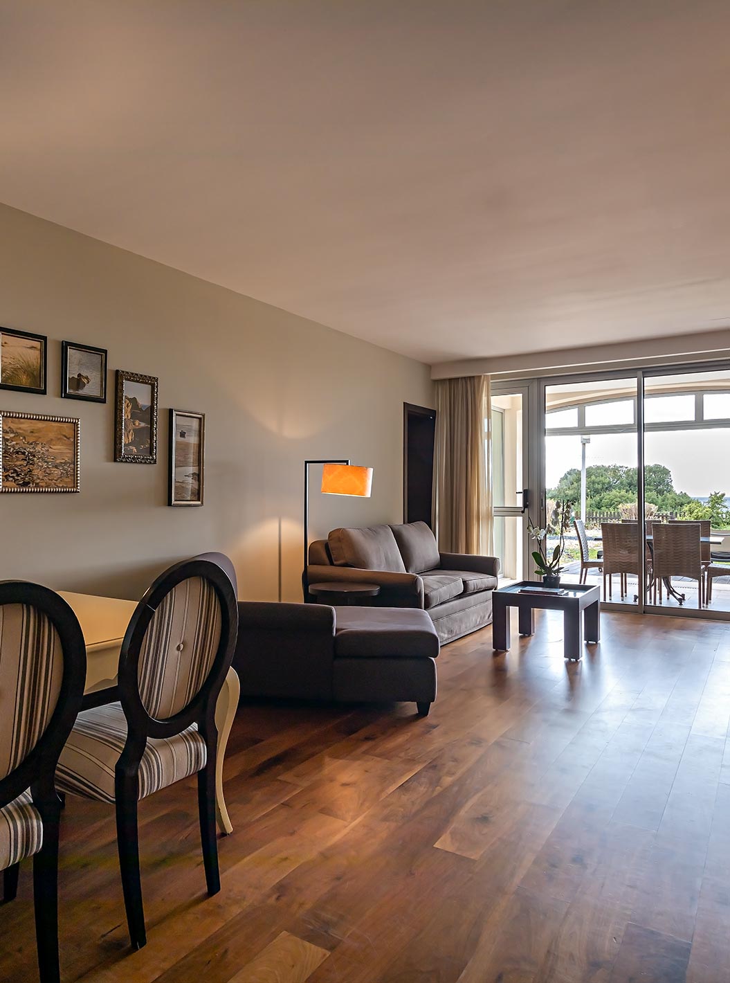 De Cliff Suite T2 in Pestana Alvor Praia heeft een woonkamer met twee banken, een televisie, een eettafel en een veranda