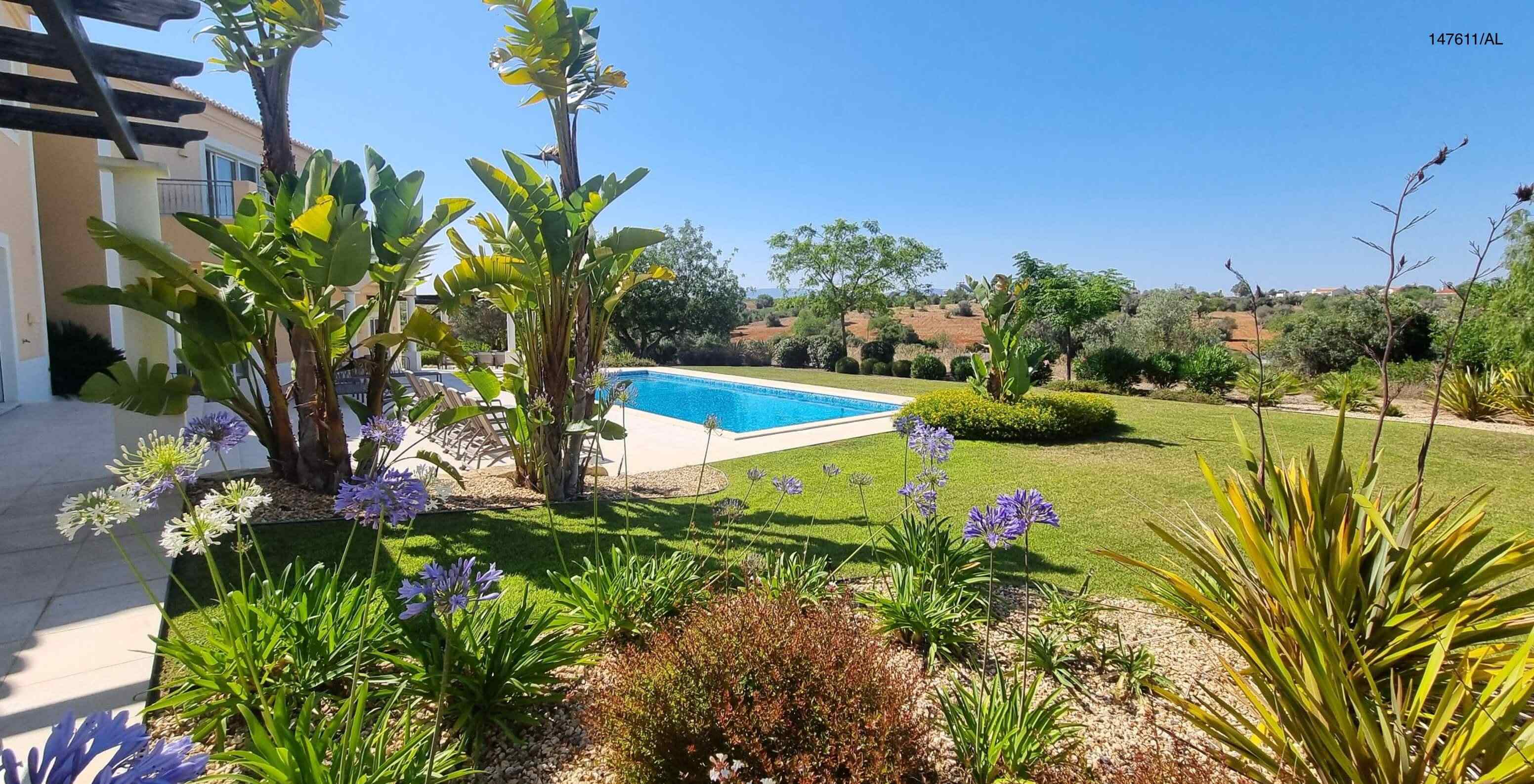 De villa Pestana Carvoeiro Golf V5 Superior heeft een buitenruimte met een zwembad, een gazon en bomen eromheen