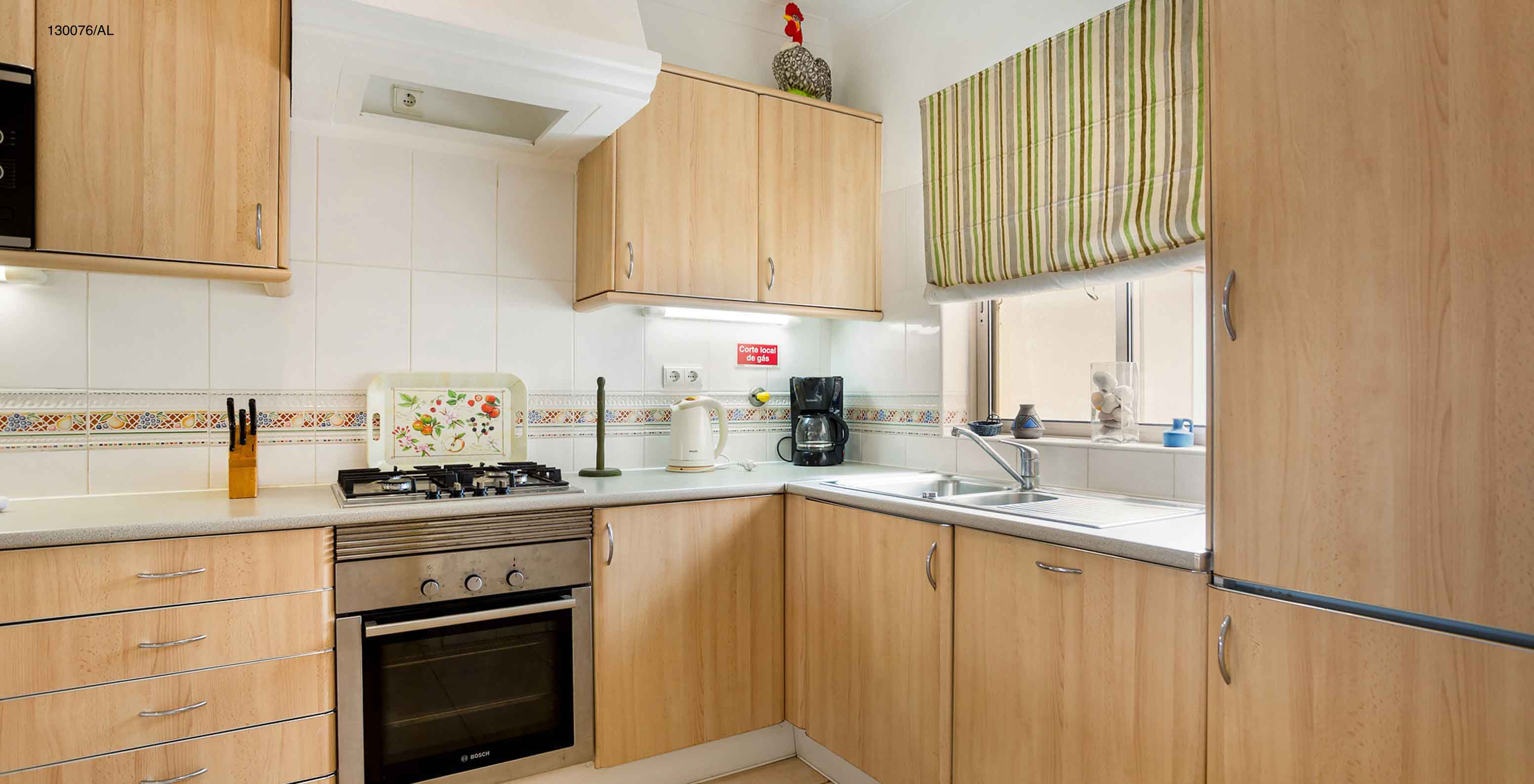 Het appartement Pestana Carvoeiro Golf T2 Standard heeft een keuken met houten kasten en apparatuur