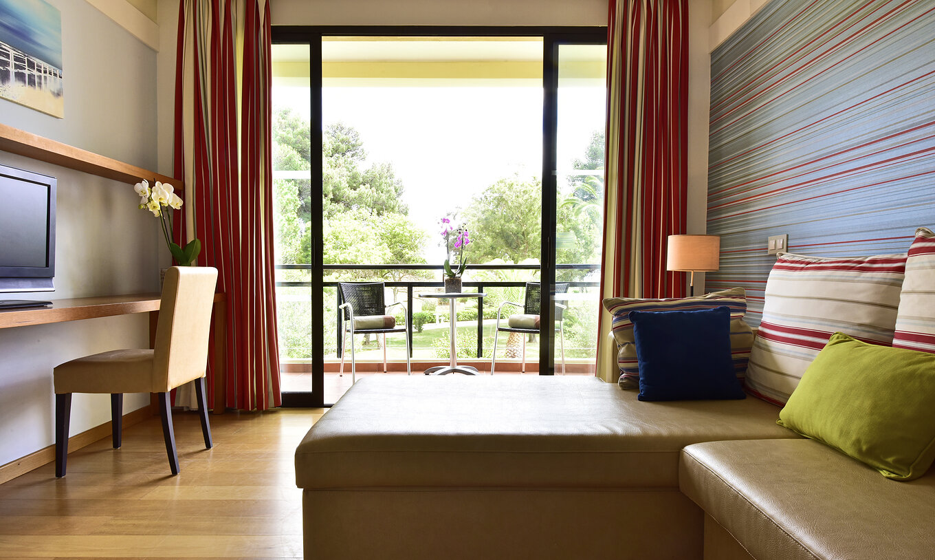 De Suite Standard van Pestana Dom João II heeft een balkon met uitzicht op de tuin, een bank met chaise longue en televisie