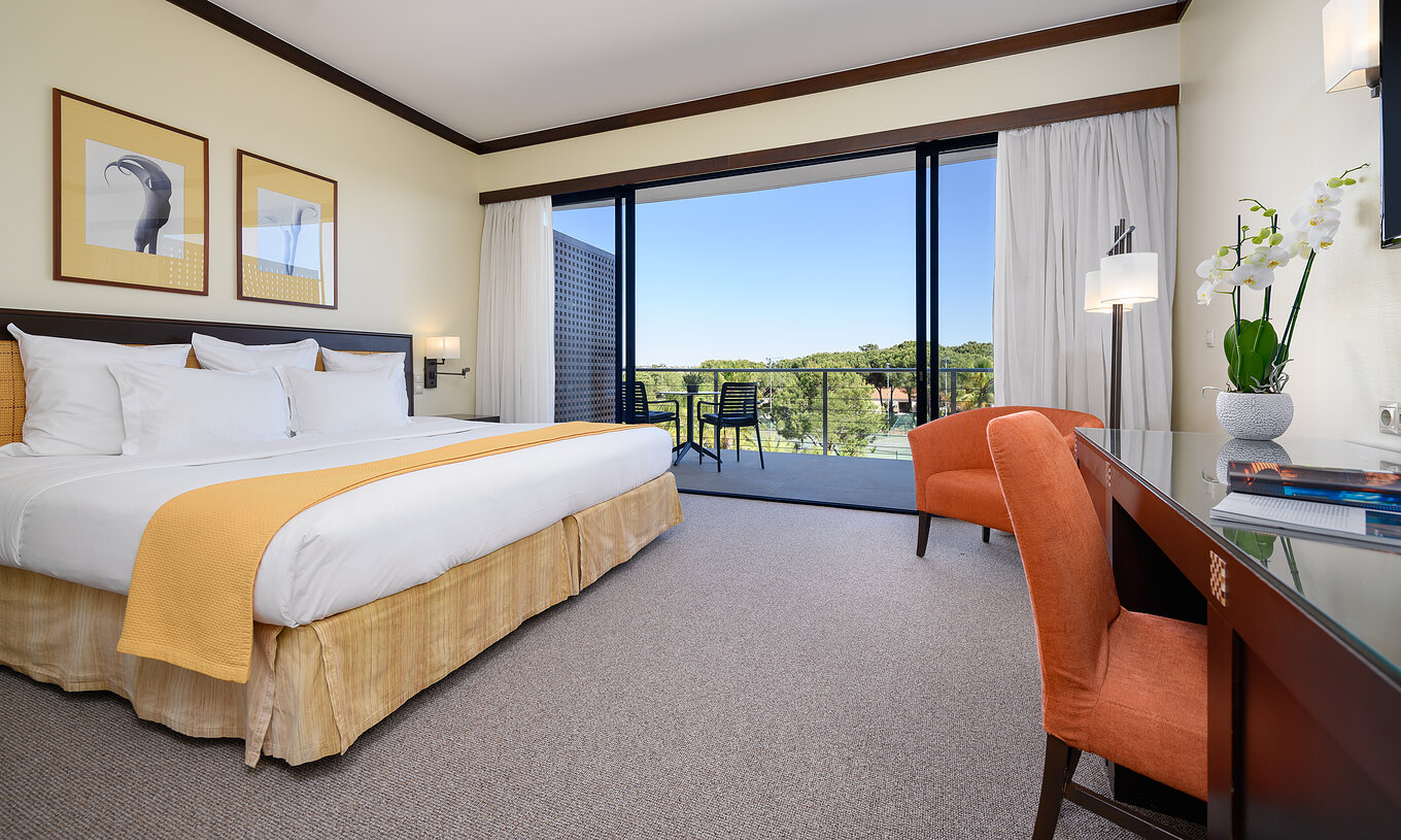 De Superieur kamer van Pestana Vila Sol - Vilamoura heeft een tweepersoonsbed, bureau, fauteuil en balkon met stoelen