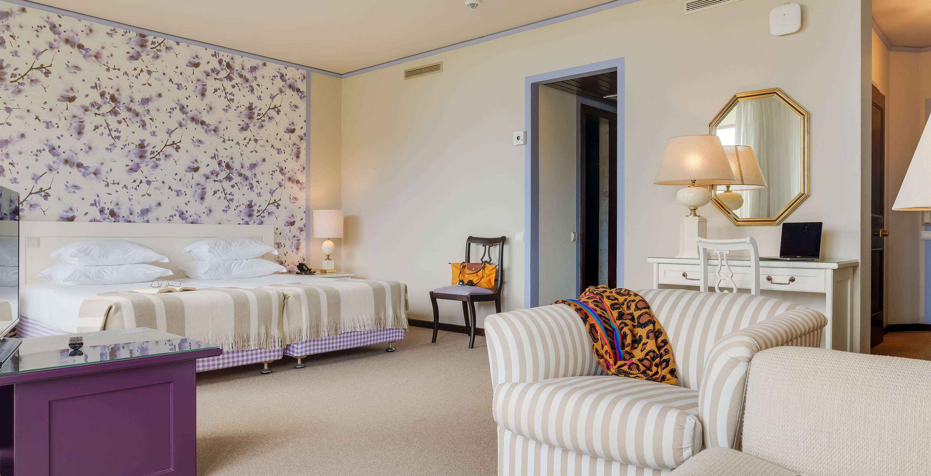 In Junior Suite Tuinzicht van Pestana Bahia Praia staan de bedden naast het balkon met uitzicht op tuinen en zee