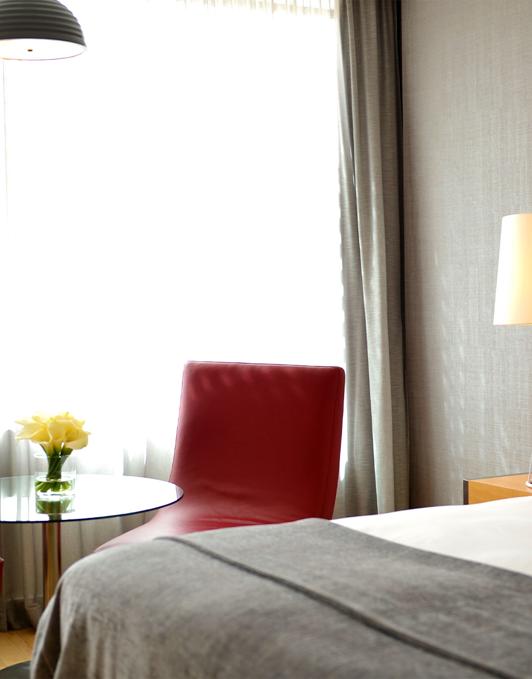 De Superior Room met Balkon van Pestana Cidadela Cascais heeft een tweepersoonsbed en een kleine tafel met een rode stoel