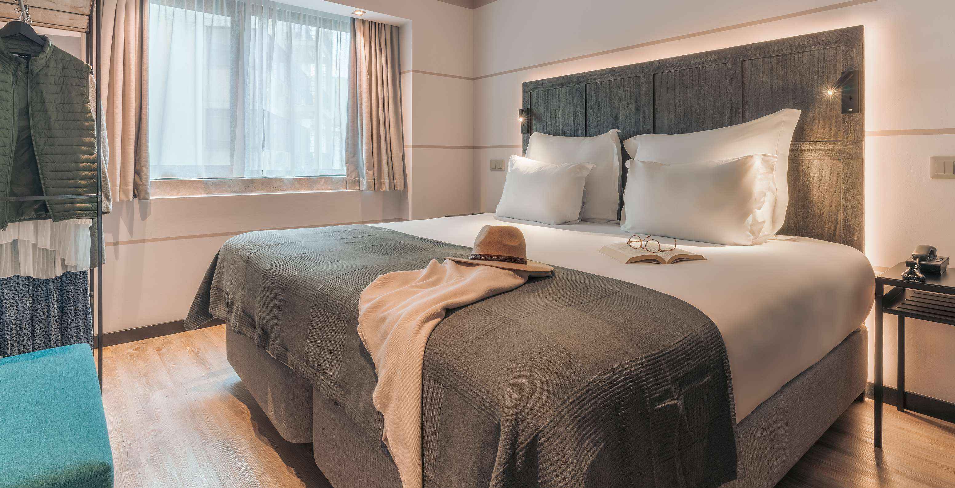 De Junior Suite Van Pestana Lisboa Vintage Heeft Een Tweepersoonsbed Met Deken Een Blauwe Bank Nachtkastje En Een Kast