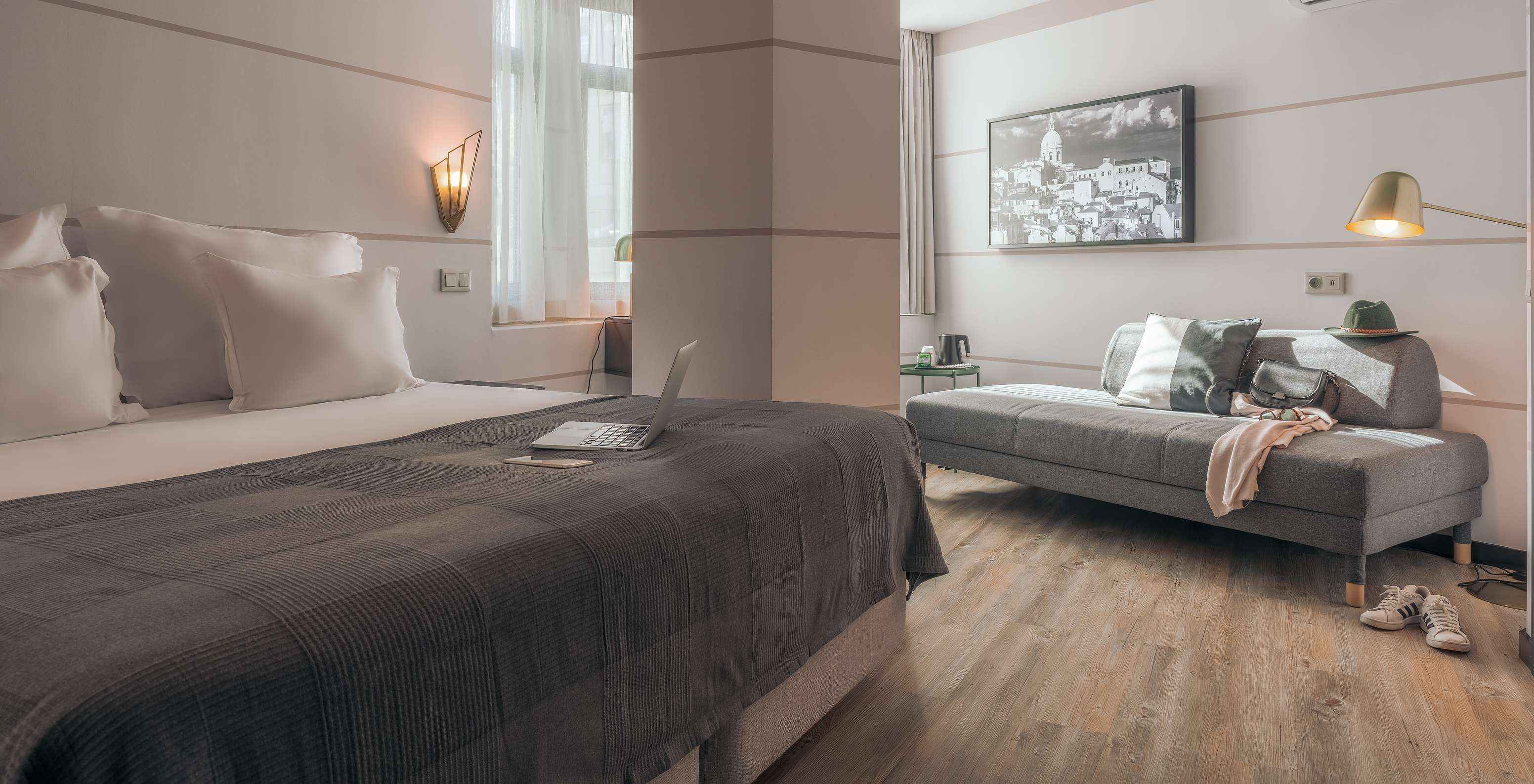 De Double Superior Van Pestana Lisboa Vintage Heeft Een Tweepersoonsbed Met Grijze Deken Een Grijze Bank En Witte Sneakers