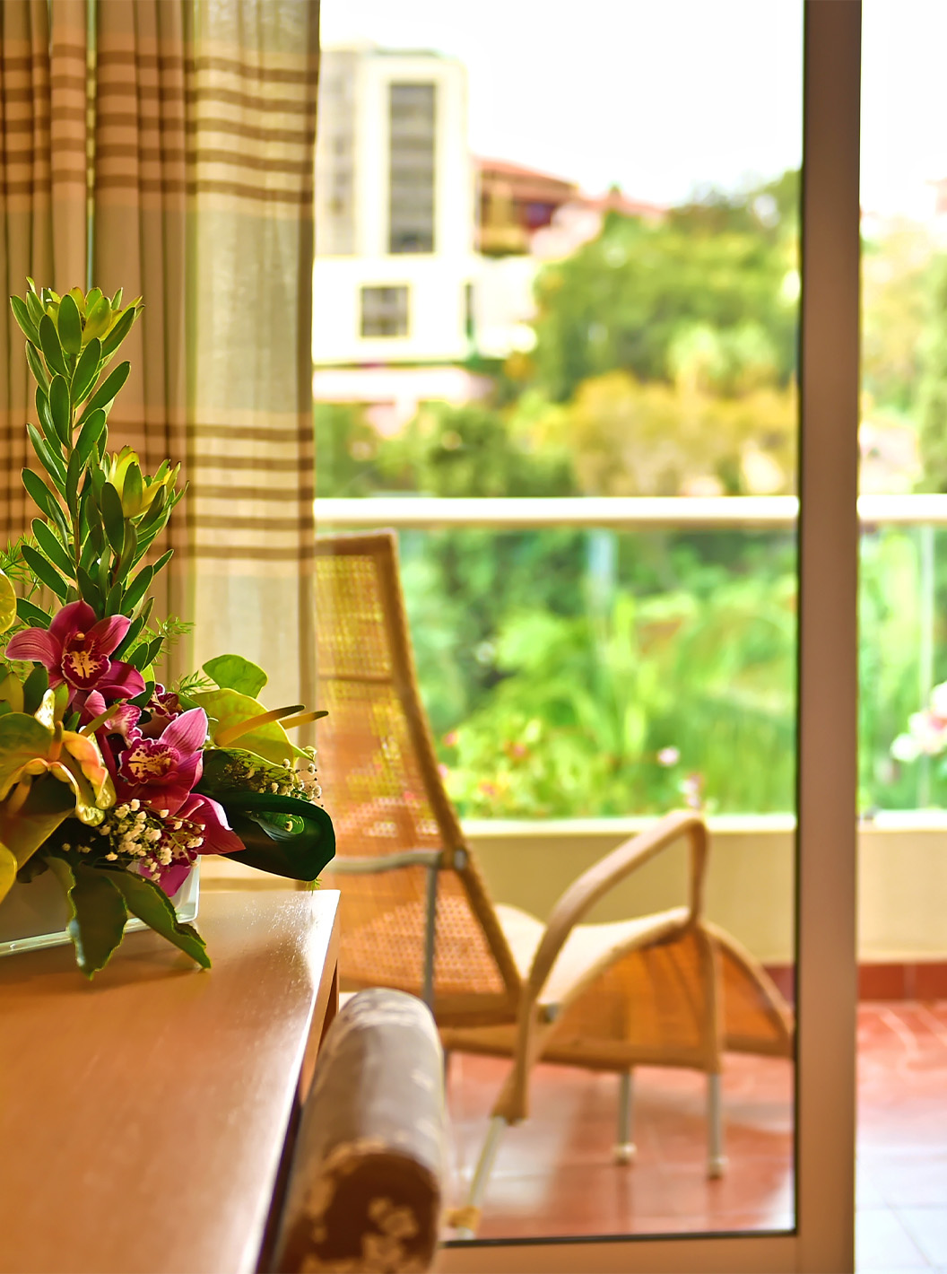 De Classic Twin Pool View van Pestana Carlton Madeira heeft een dressoir met bloemen en een balkon met tafel en stoelen