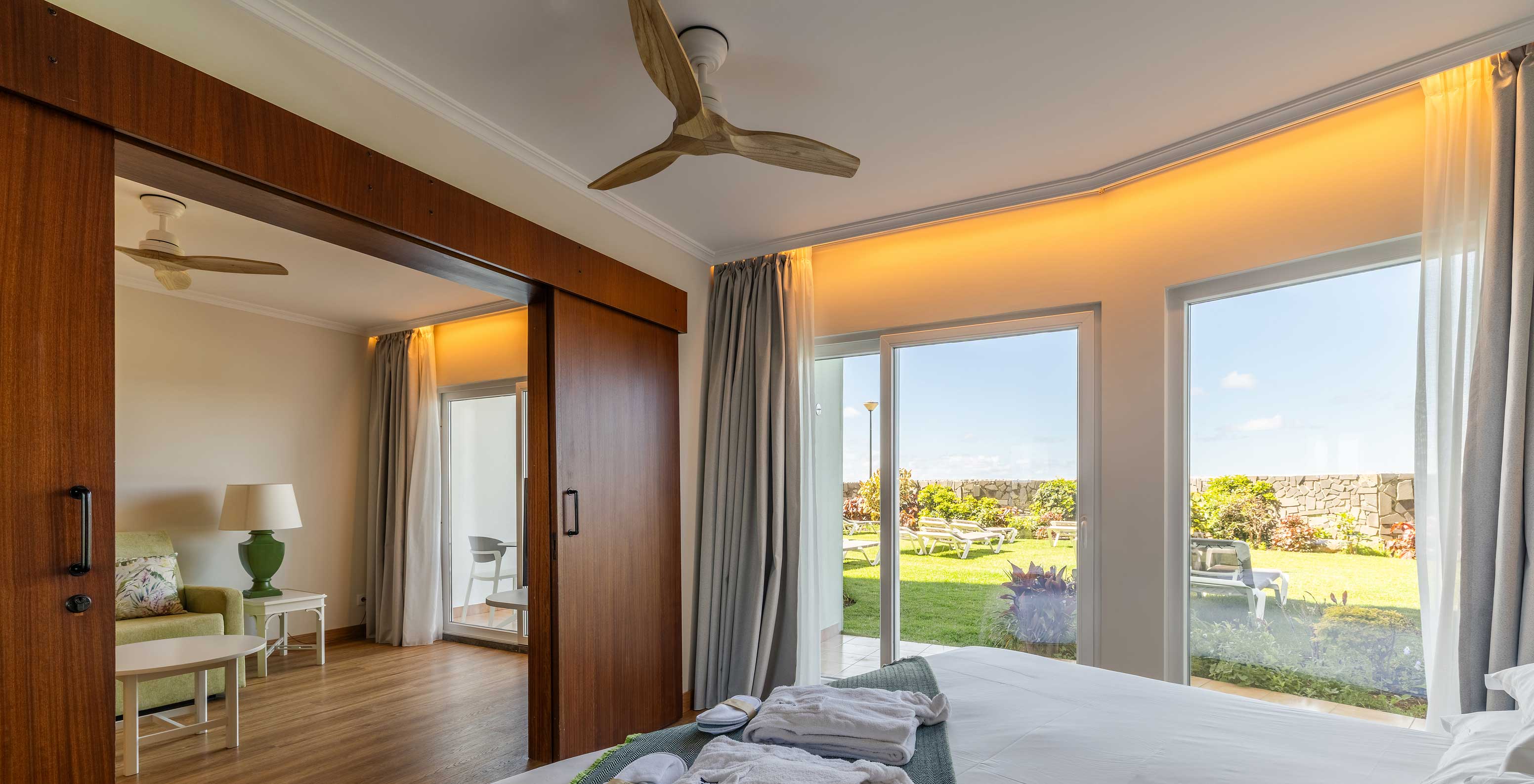 De Junior Suite Sea View van het Pestana Ocean Bay All Inclusive heeft een tweepersoonsbed met uitzicht op de tuin