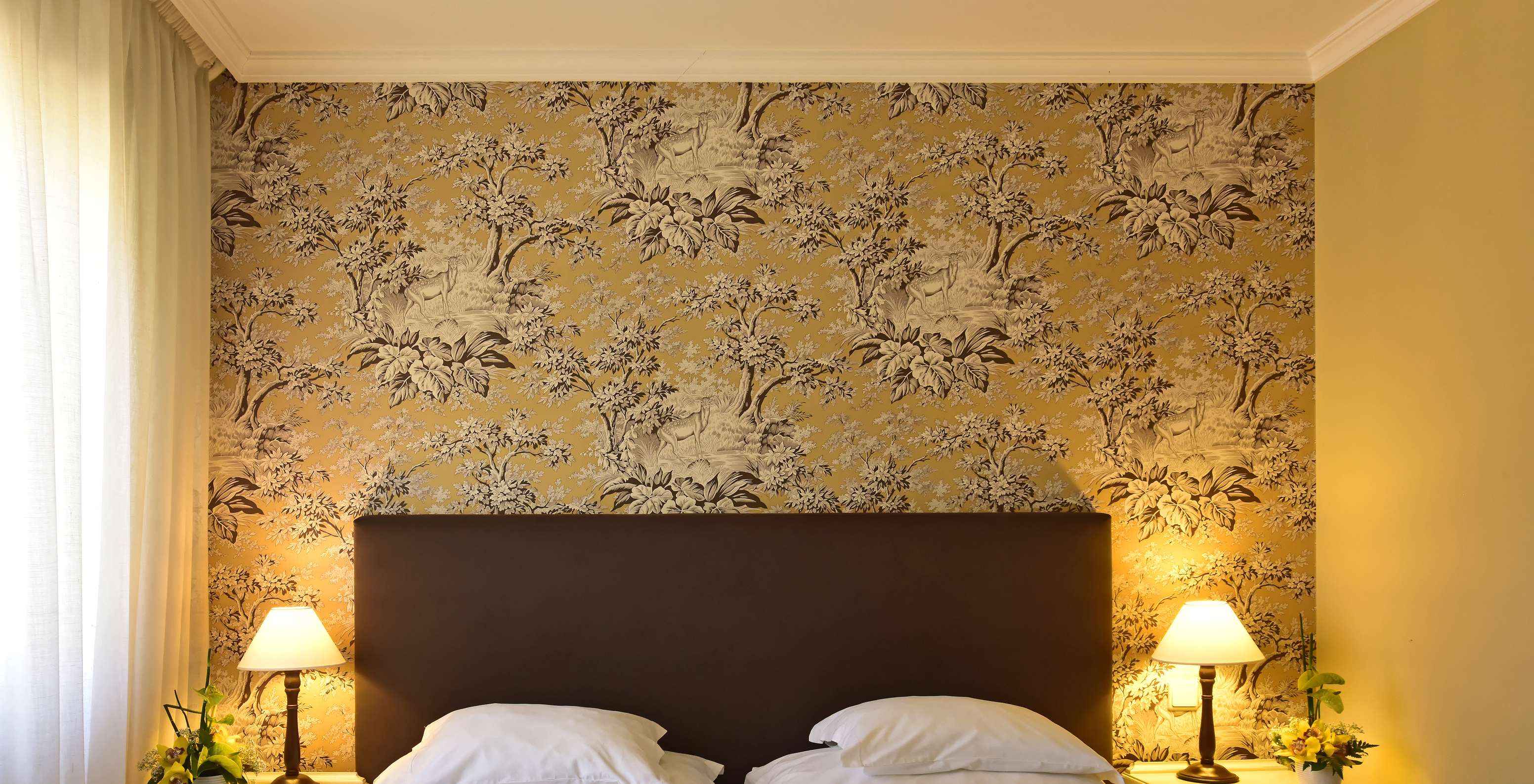 De Suite met Jacuzzi van Pestana Village heeft een tweepersoonsbed met hoofdeinde en kastanjebruin dekbed en behang