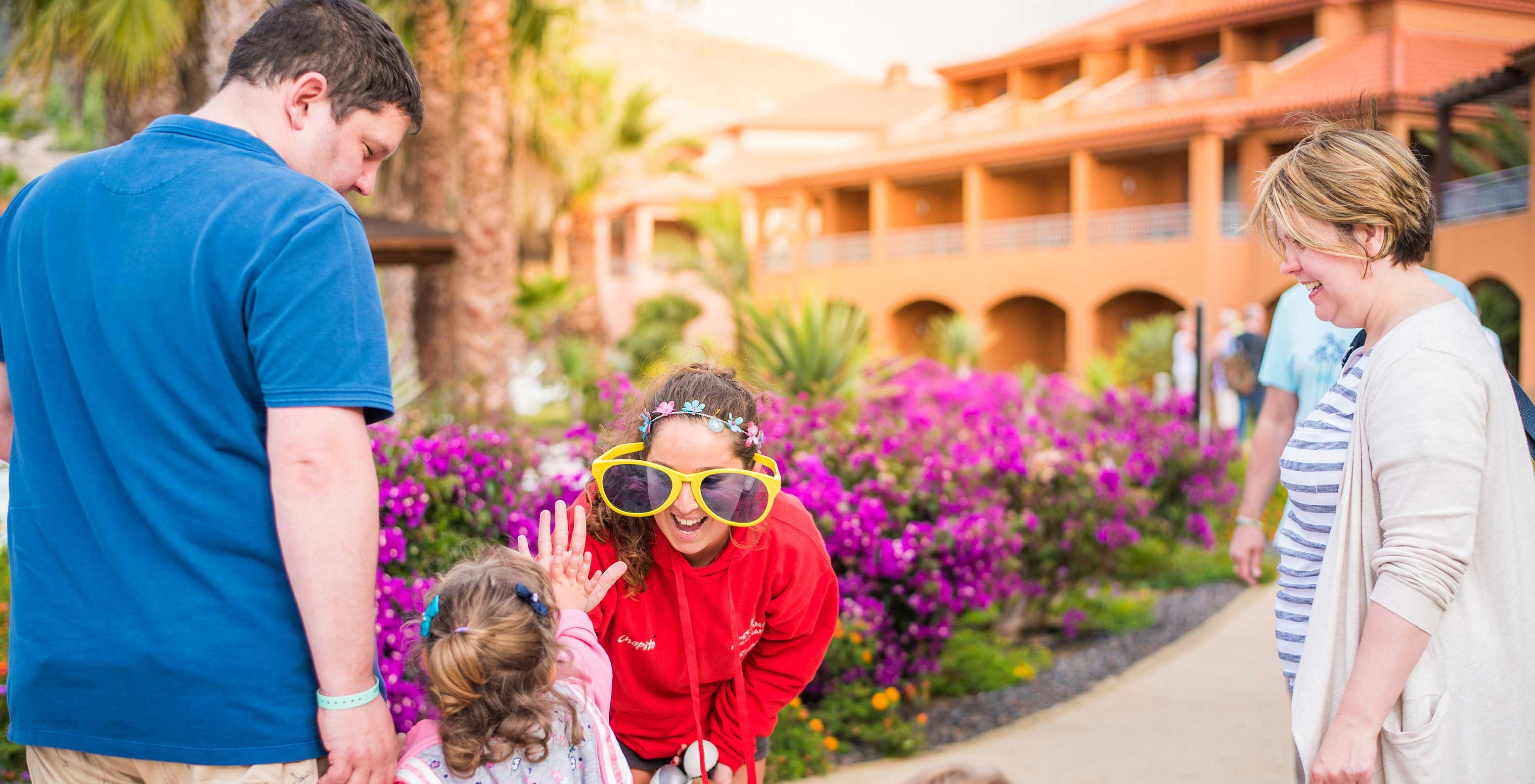 Familie plezier in Pestana Porto Santo, grote zonnebrillen, paarse bloemen op zonnige dag
